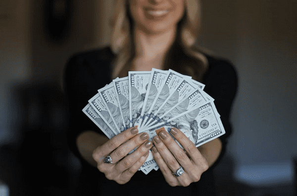 Mujer sosteniendo un abanico de dólares. | Foto: Pixabay