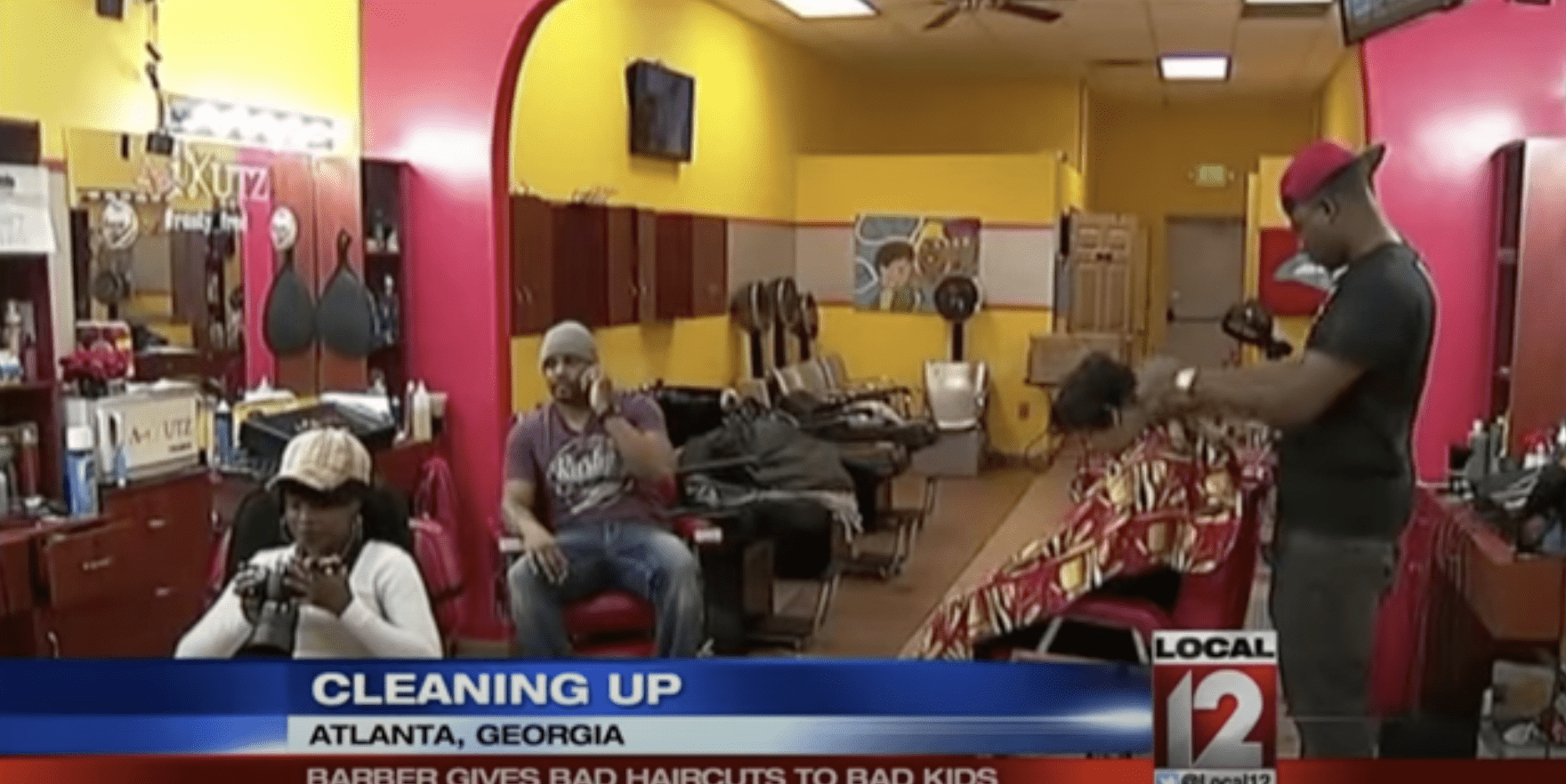 Russell Fredrick and other barbers pictured inside his Atlanta salon. | Source: YouTube.com/LOCAL 12