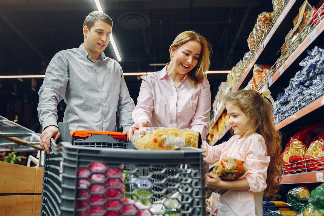 Una pareja con una niña realizando las compras en un supermercado. | Foto: Pexels