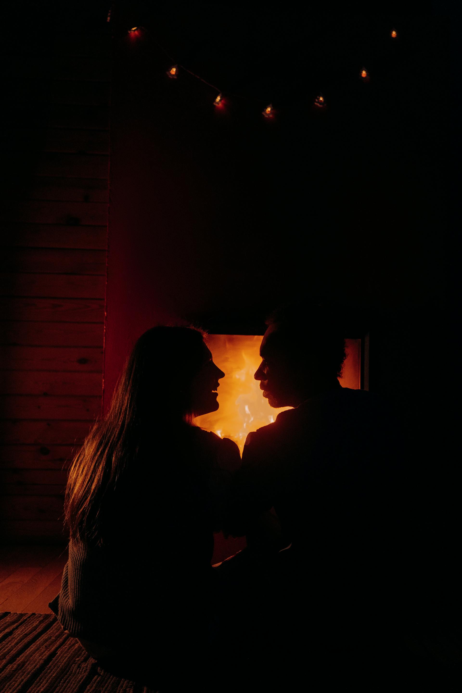 A couple sitting in front of a fire | Source: Pexels