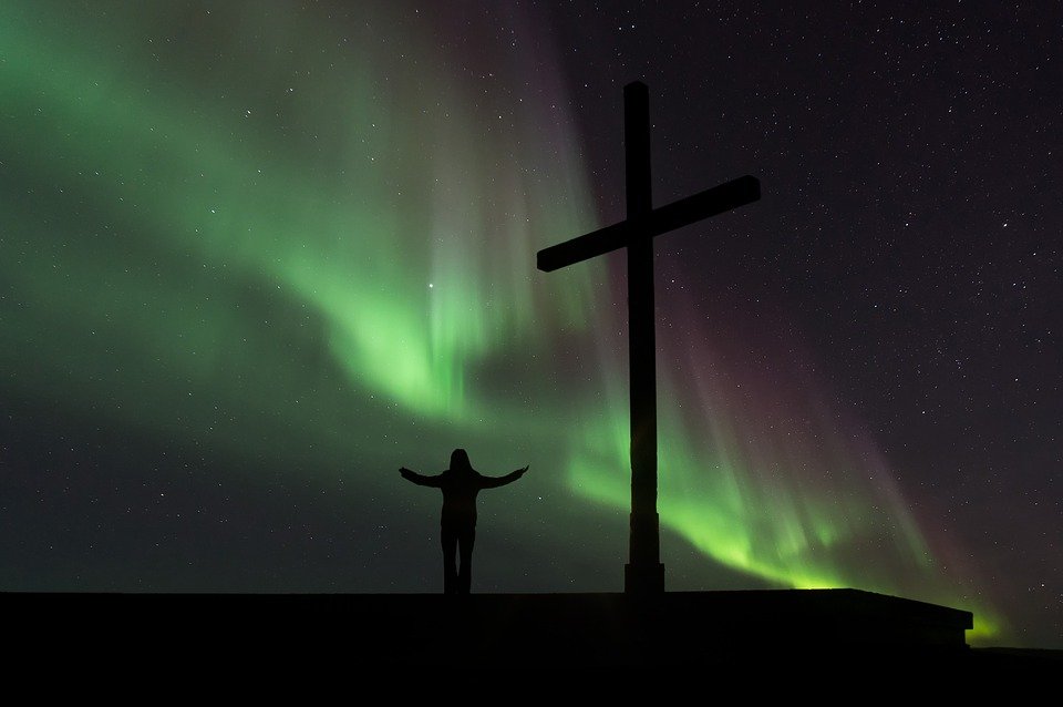 Persona rezando frente a una cruz.| Imagen tomada de: Pixabay