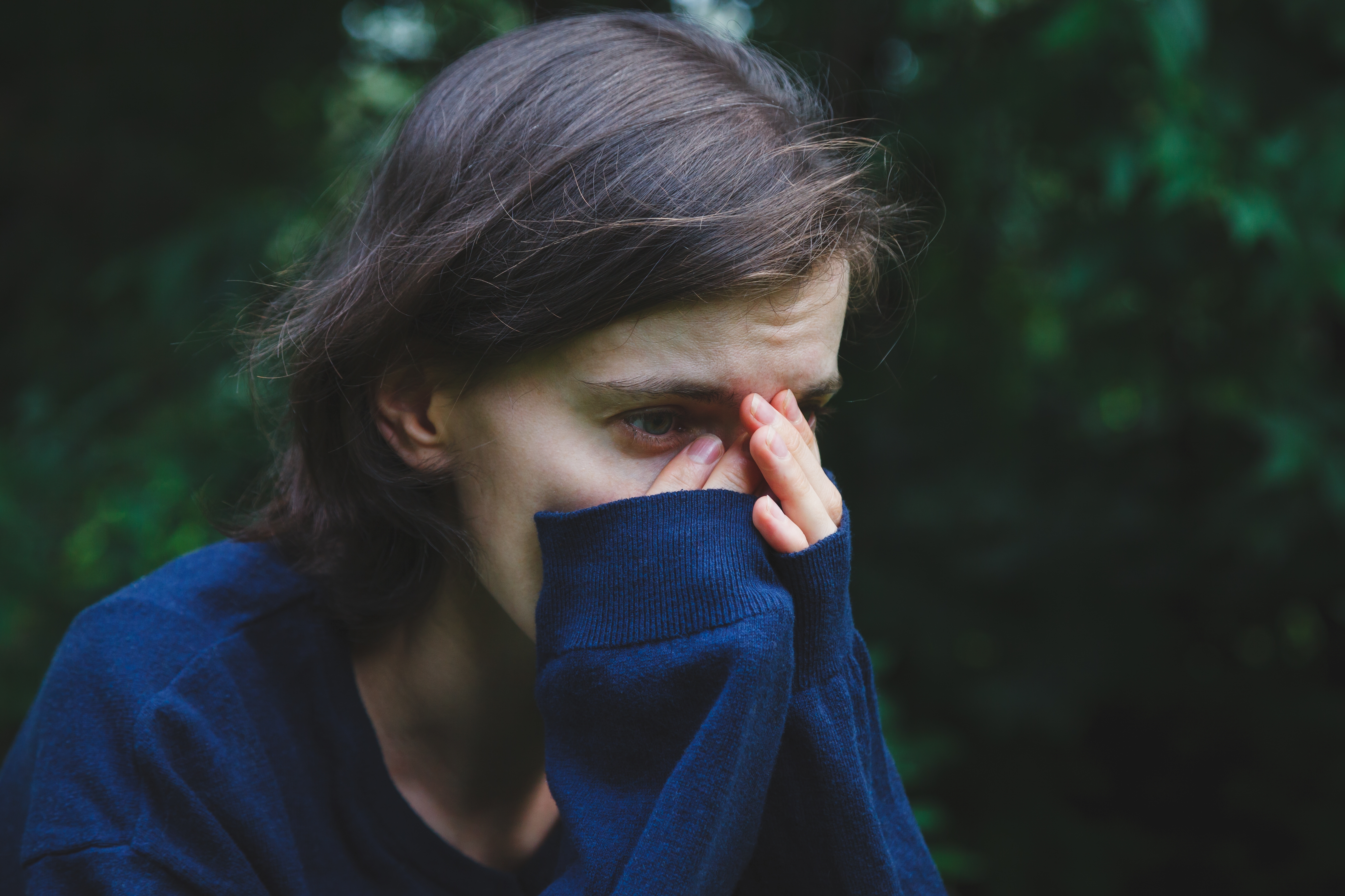 An upset looking woman covering her face with her hands | Source: Shutterstock