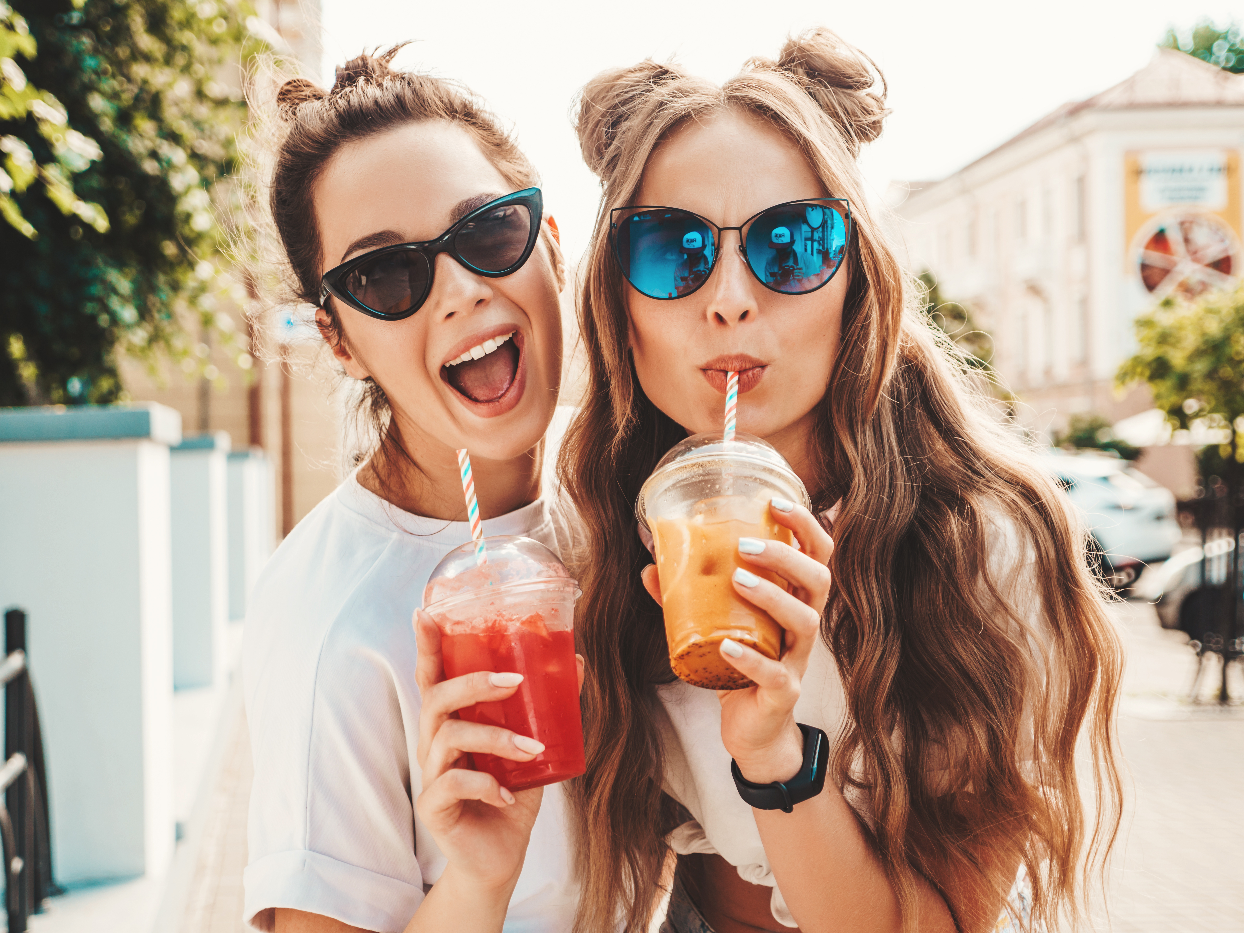 Two friends enjoying smoothies | Source: Shutterstock