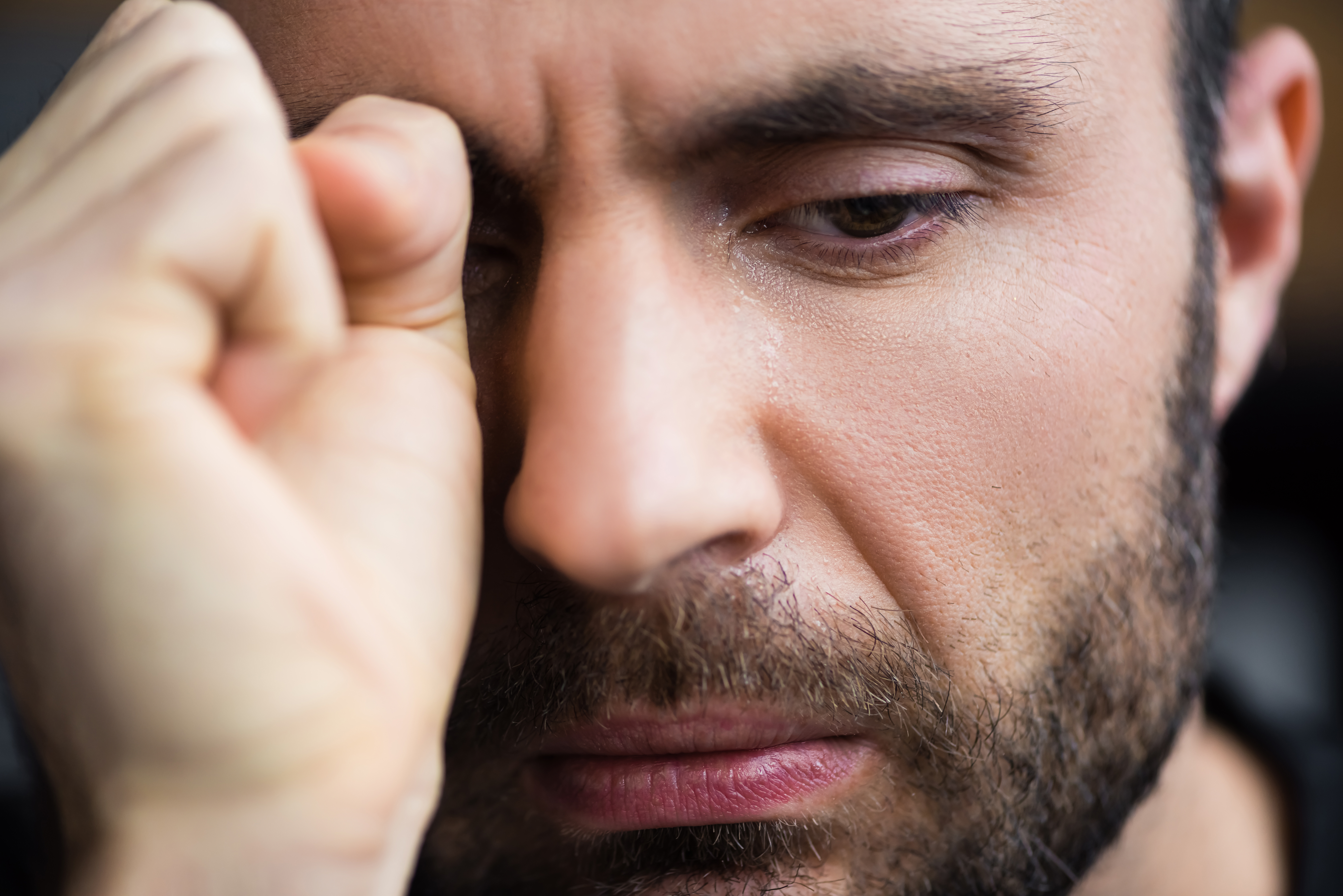 A sad man wiping a tear | Source: Shutterstock