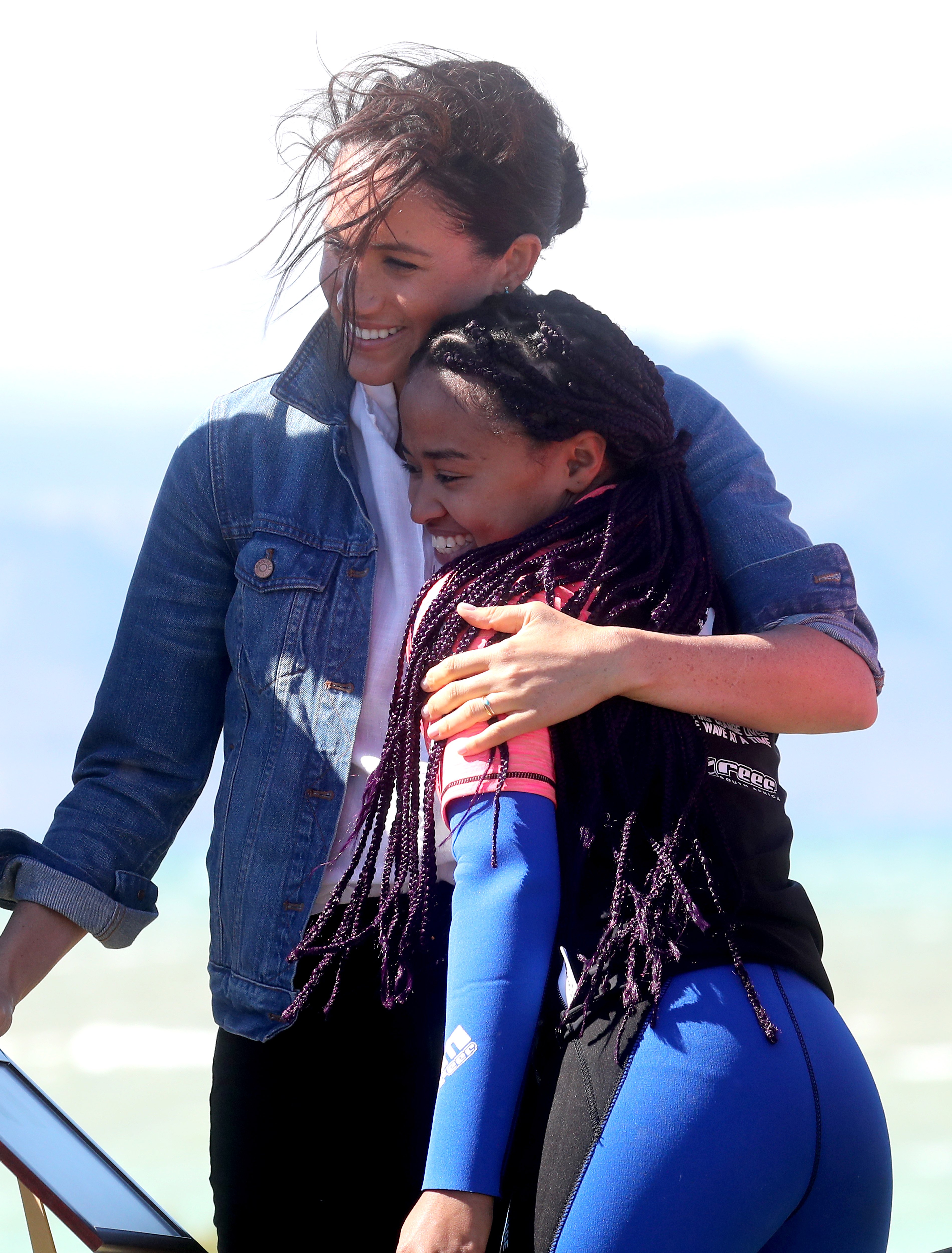 Meghan, Duchess of Sussex hugs a surf mentor as she visits Waves for Change, an NGO, at Monwabisi Beach, with Prince Harry, Duke of Sussex on September 24, 2019 | Source: Getty Images