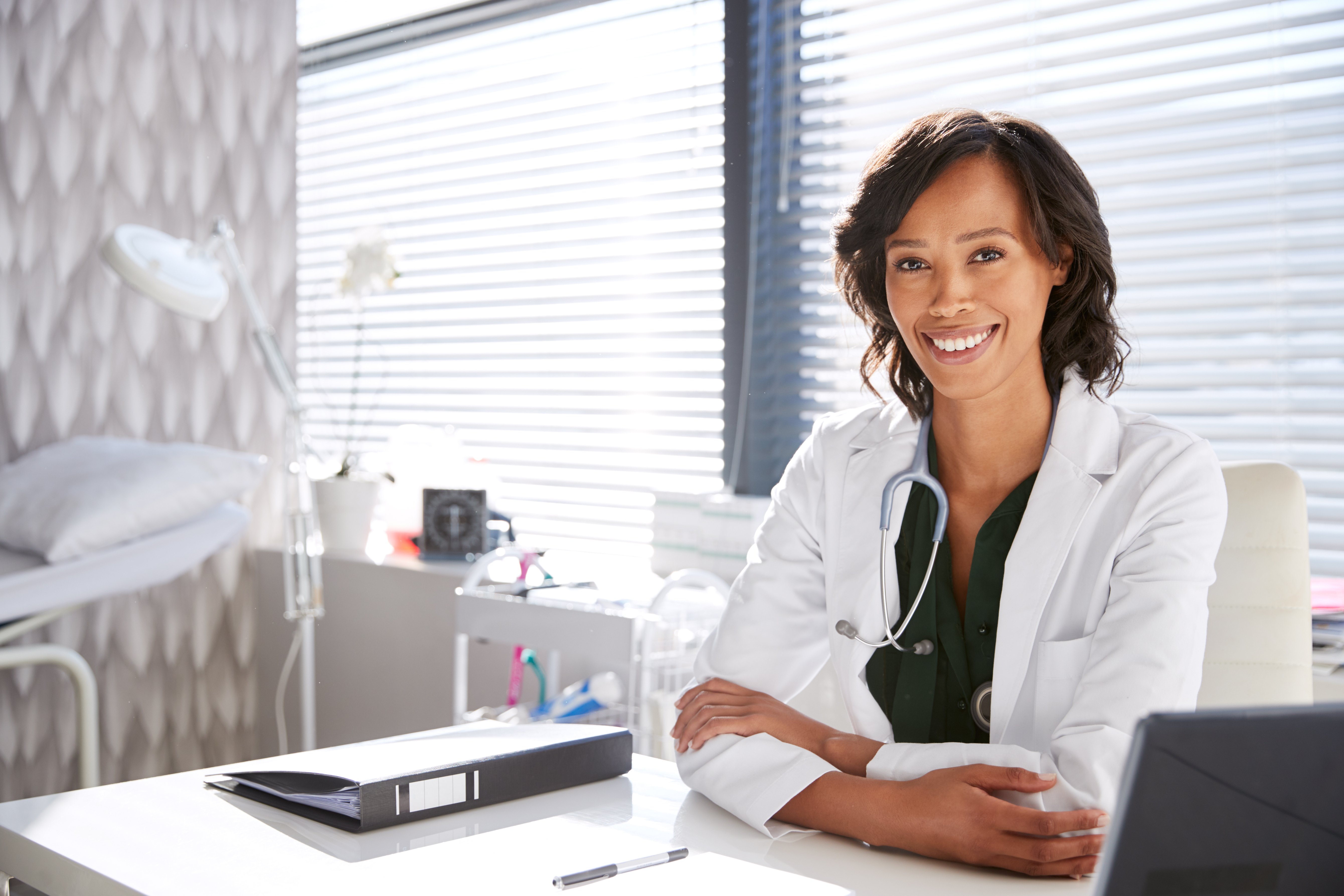 Doctora sonriendo en su consultorio. | Foto: Shutterstock