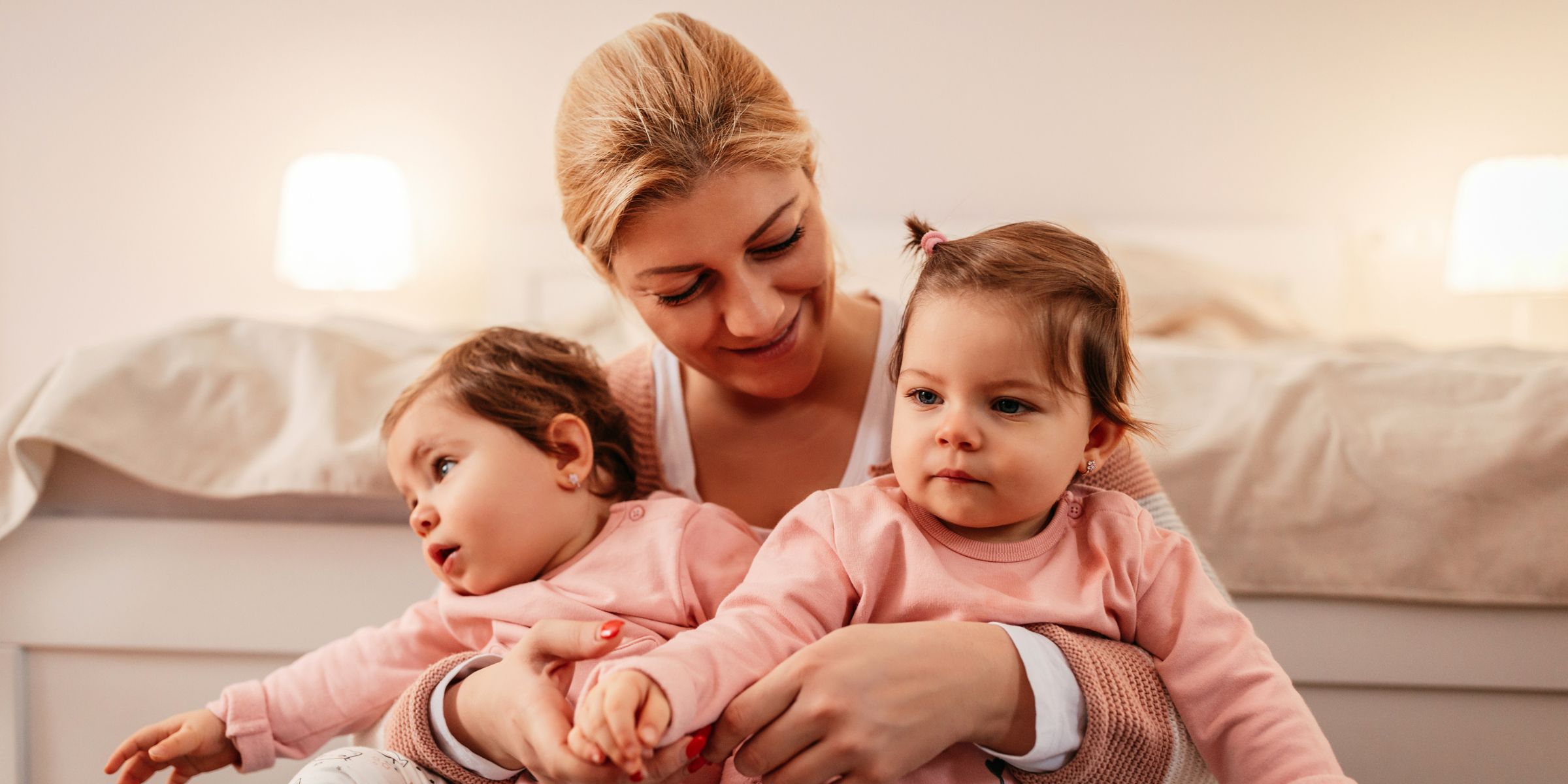 A woman holding twin baby girls | Source: Shutterstock