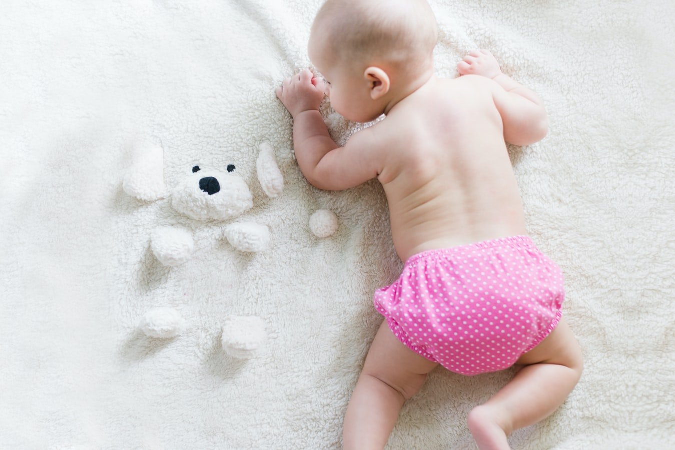 Un bébé près d'une peluche. l Source : Unsplash