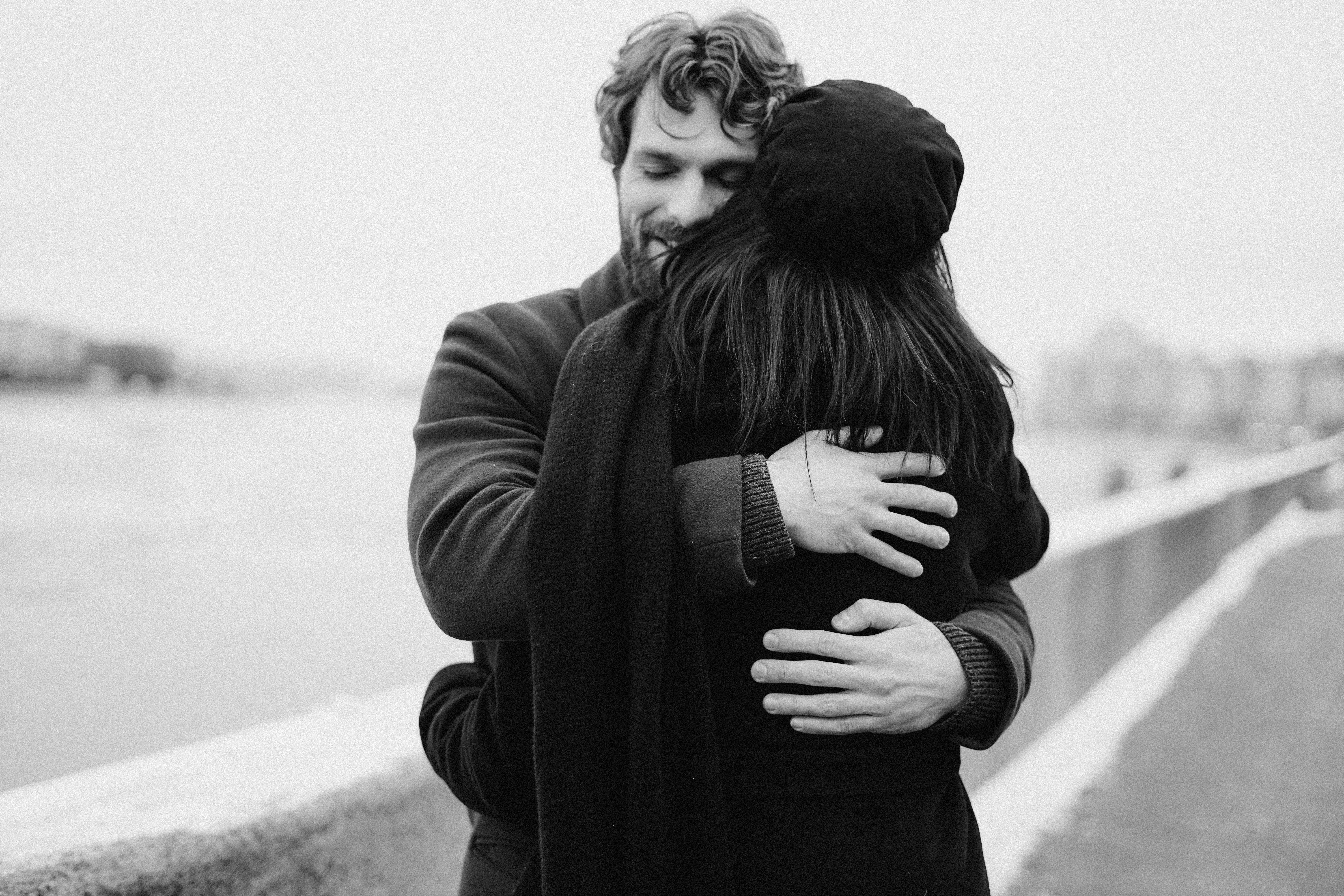 Man and woman hugging on a bridge | Photo: Pexels