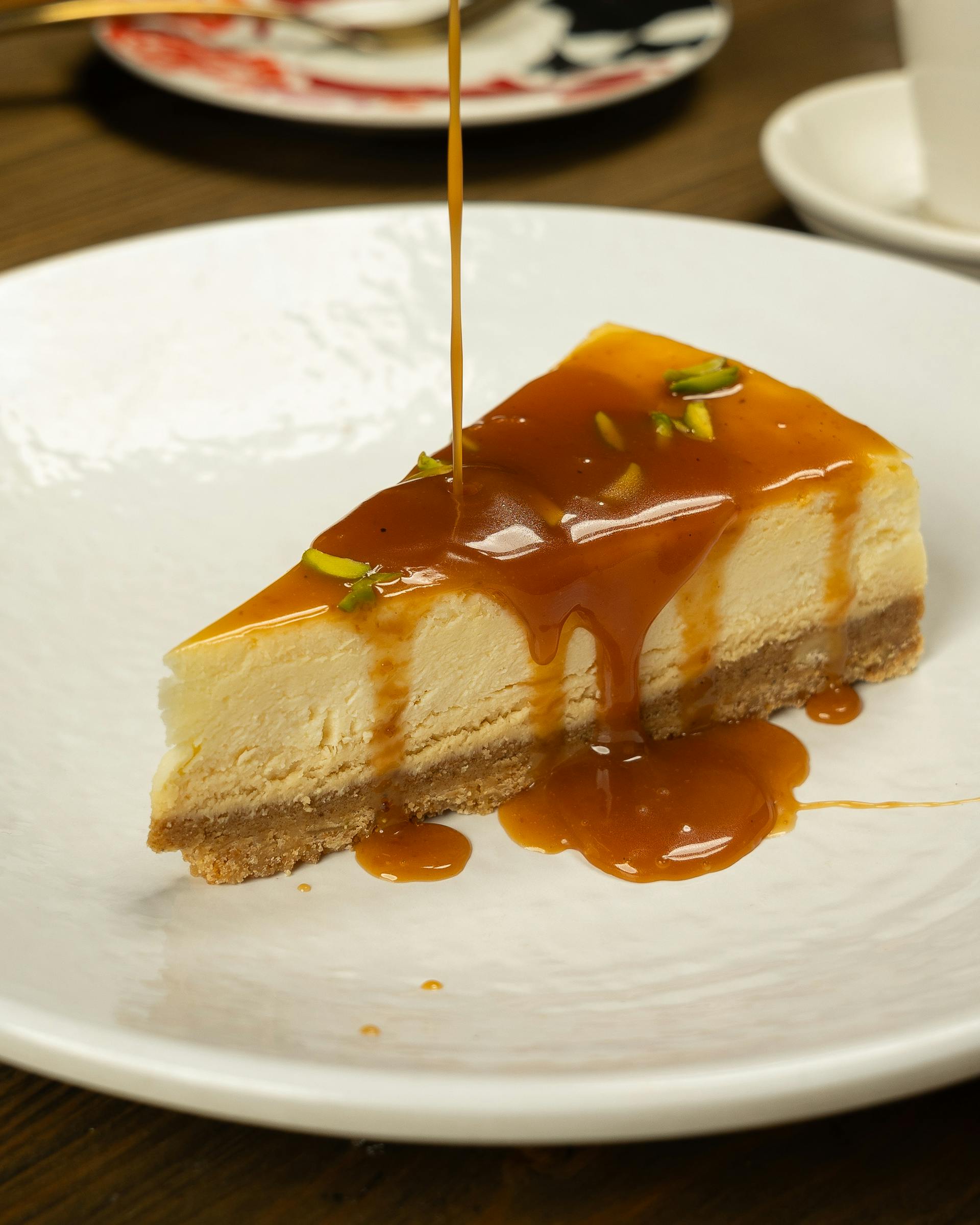 A slice of cheesecake with caramel sauce drizzled on top | Source: Pexels