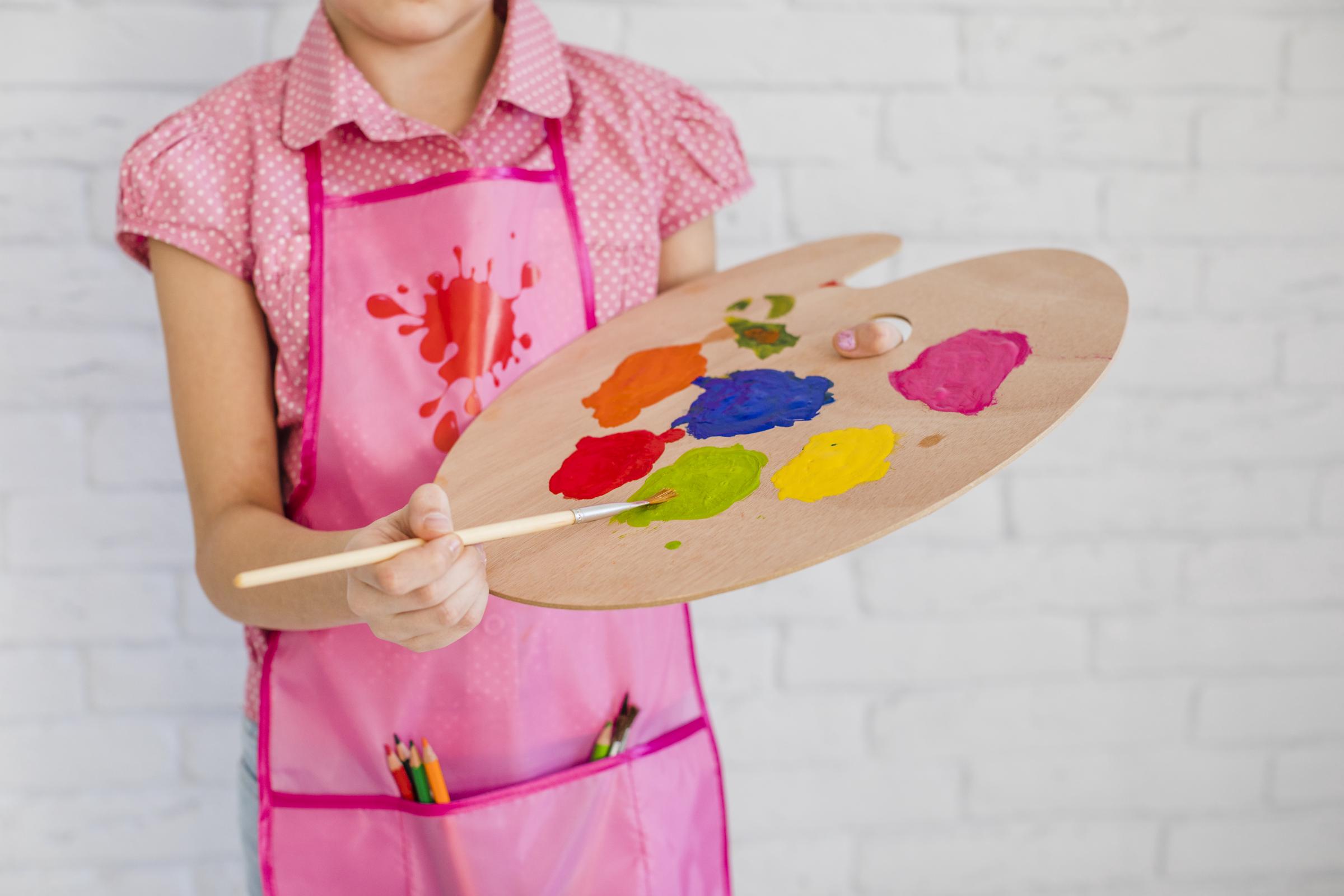 A kid holding a color palette | Source: Freepik