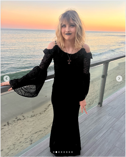 A photo of Dannielynn posing by the ocean in her gothic glam look with a stunning sunset as her backdrop  posted on September 8, 2024 | Source: Instagram/larryanddannielynn