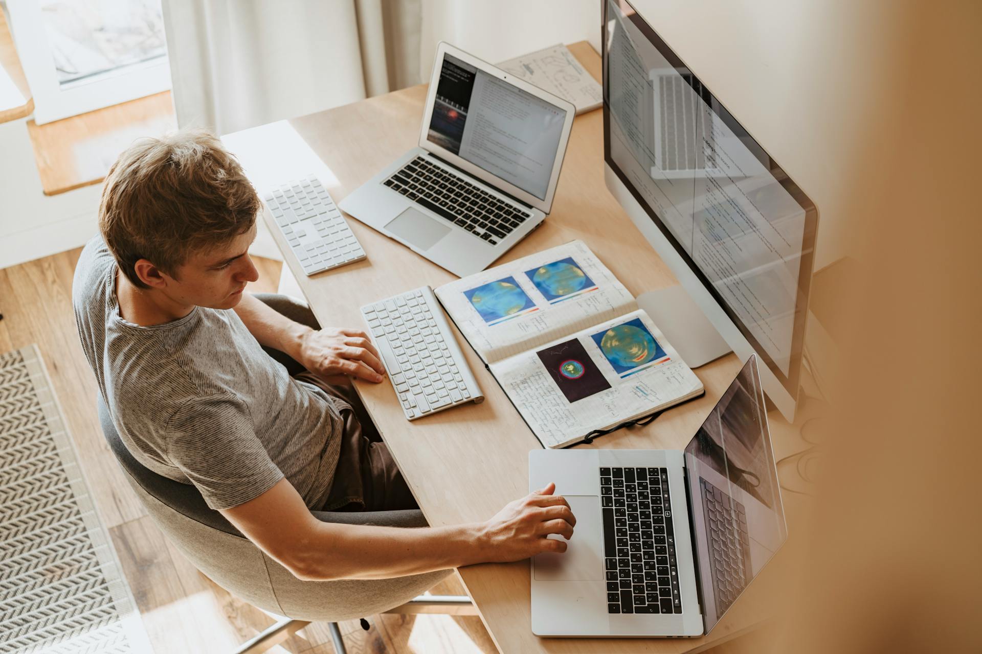 A young man using three computers | Source: Pexels