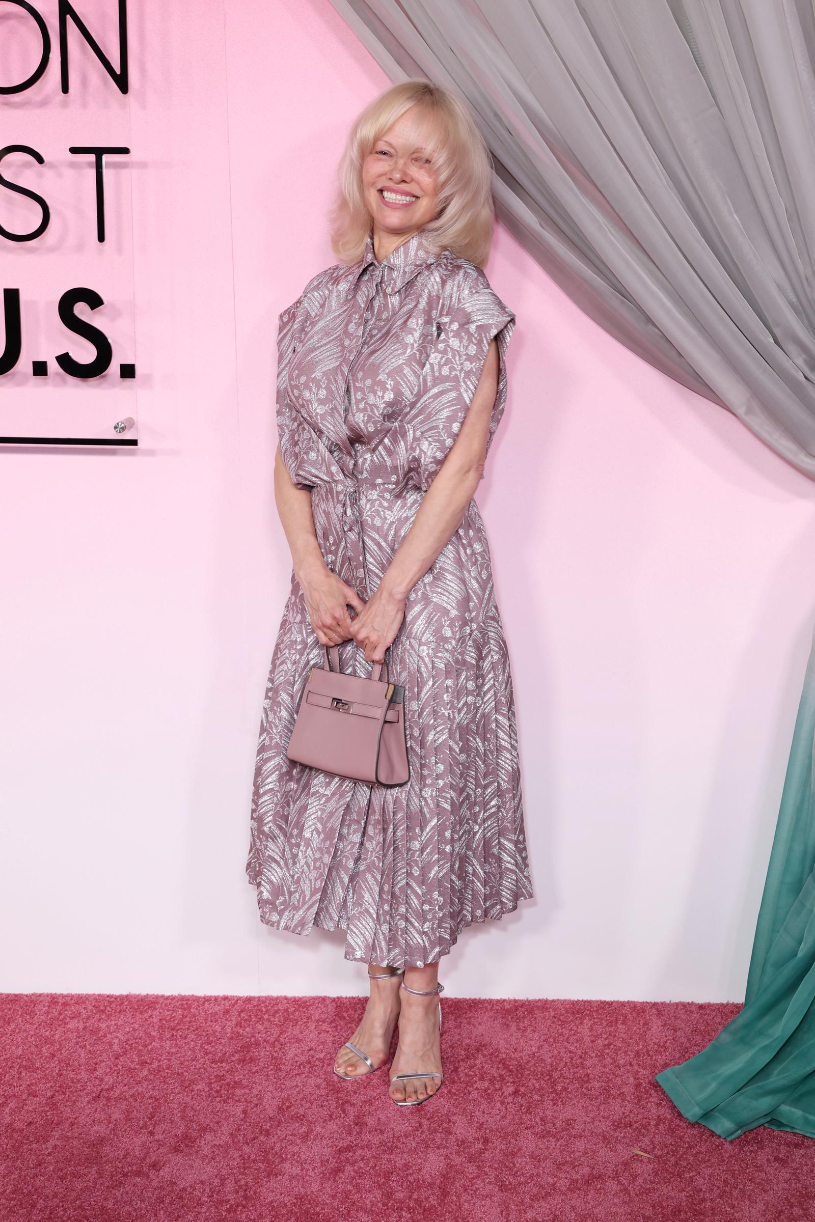 Pamela Anderson smiles while standing on the red carpet, holding a handbag at the Fashion Trust U.S. Awards 2026 | Source: Getty Images