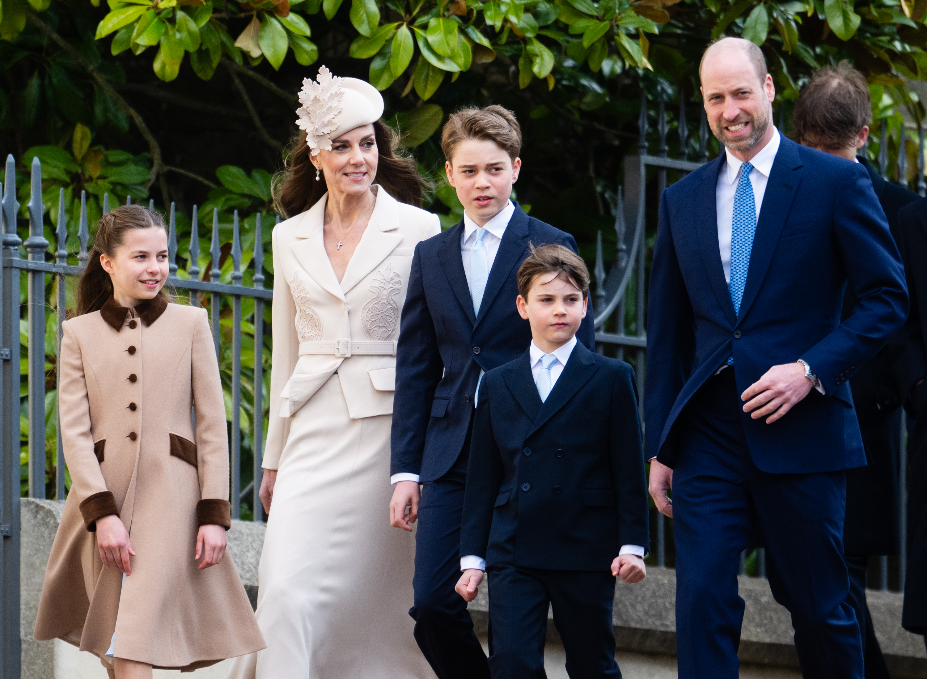 A slightly more frontal angle of the same walk, and the one that perhaps makes the height comparison most apparent of all. Prince George stands almost level with the Princess of Wales, his pale blue tie matching those of his father and brother, while Prince Louis looks directly at the camera with considerable composure for a seven-year-old.