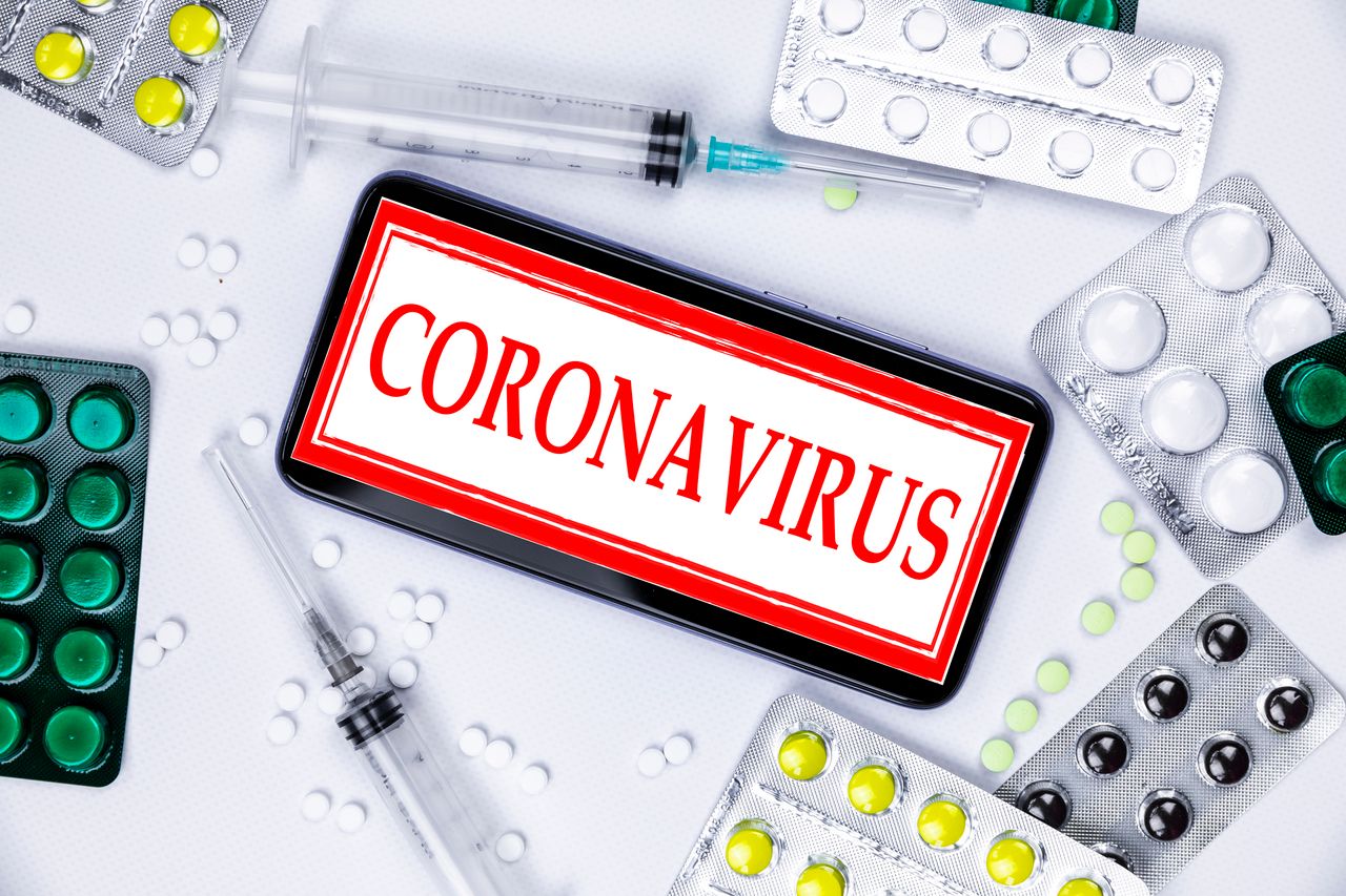 Photo of drugs and syringes dispalyed on a surface with "coronavirus" appearing boldly on a phone | Photo: Getty Images