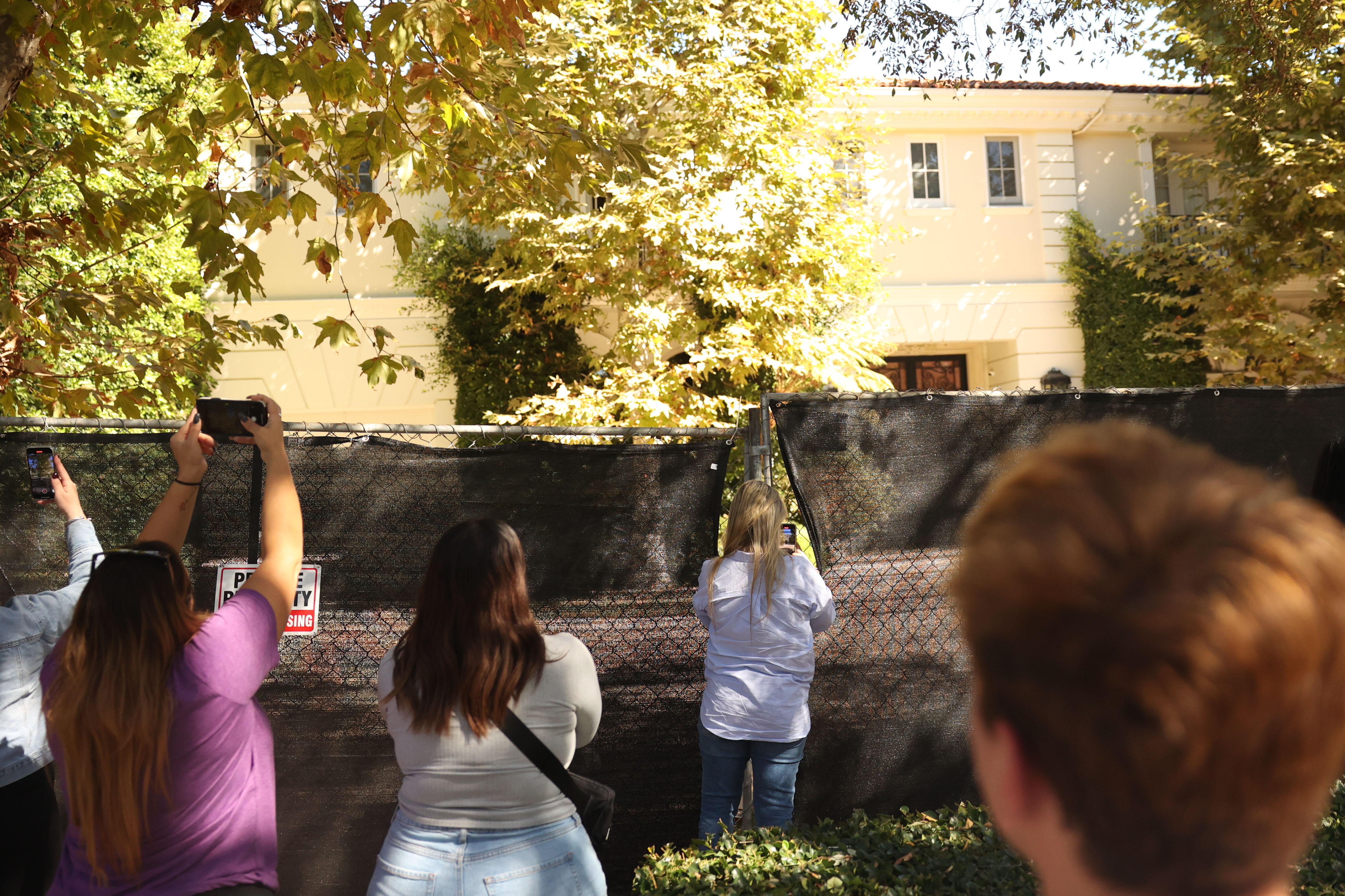 Visitors take photos of the Menendez brothers' former mansion on in Beverly Hills, California, on October, 23, 2024 | Source: Getty Images