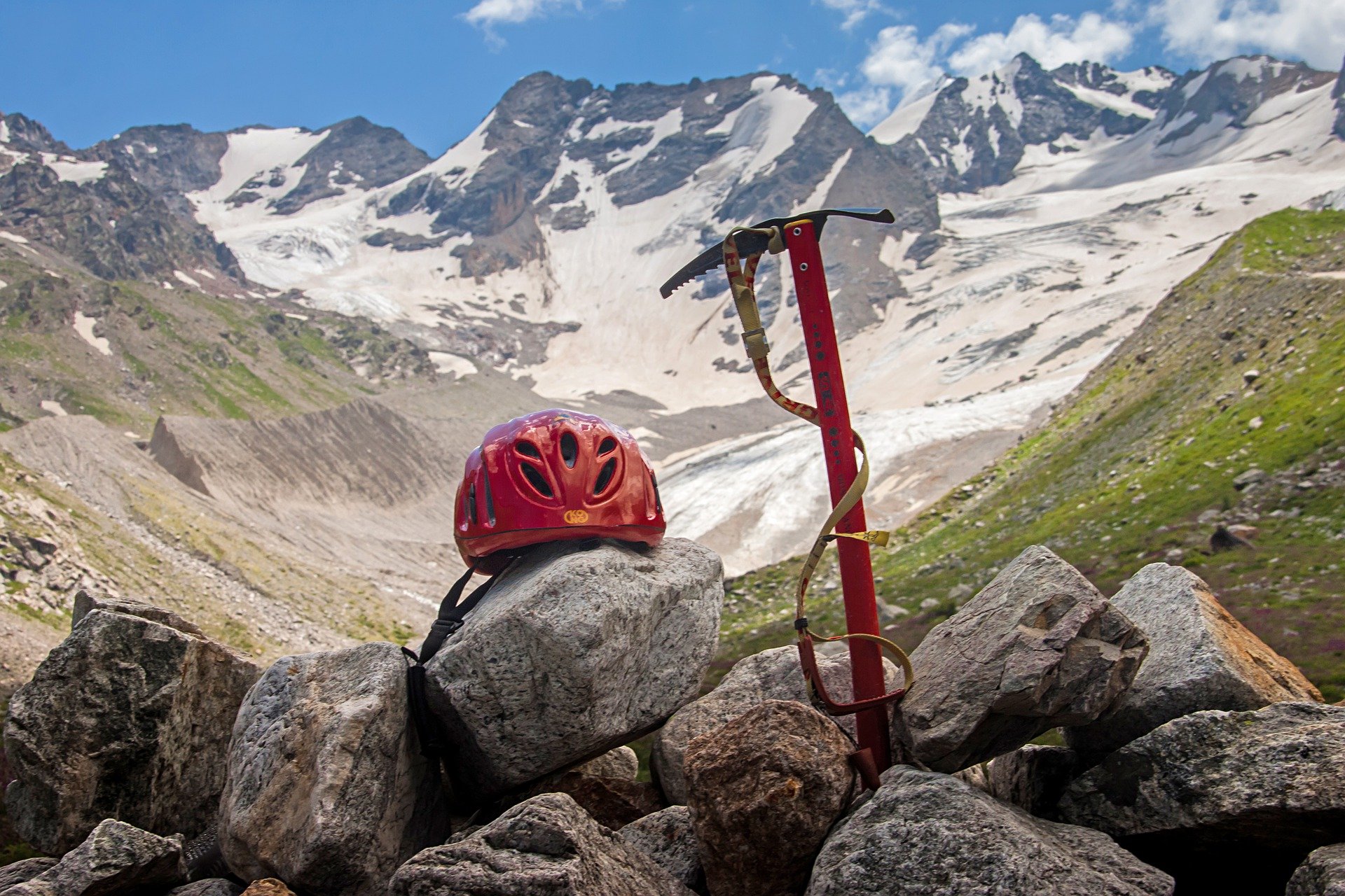 An ice pick and a helmet placed on the rocks. | Source: Pixabay.