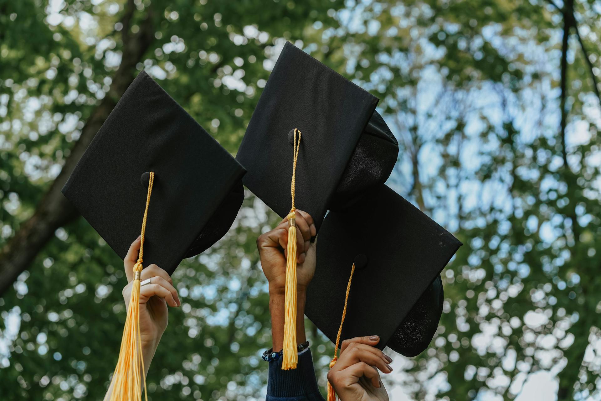People holding their graduation caps | Source: Pexels