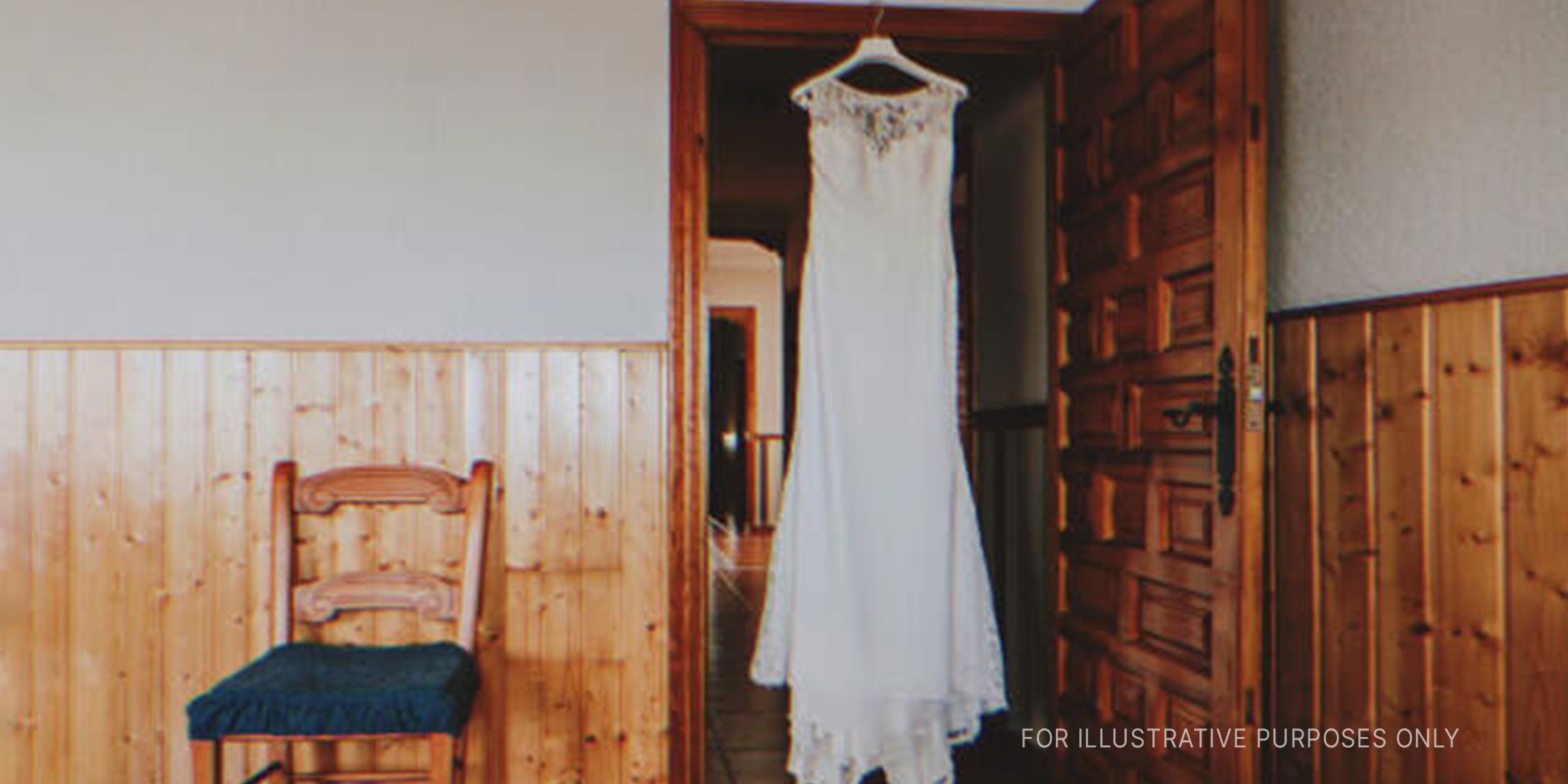 Wedding dress hanging in doorway. | Source: Shutterstock