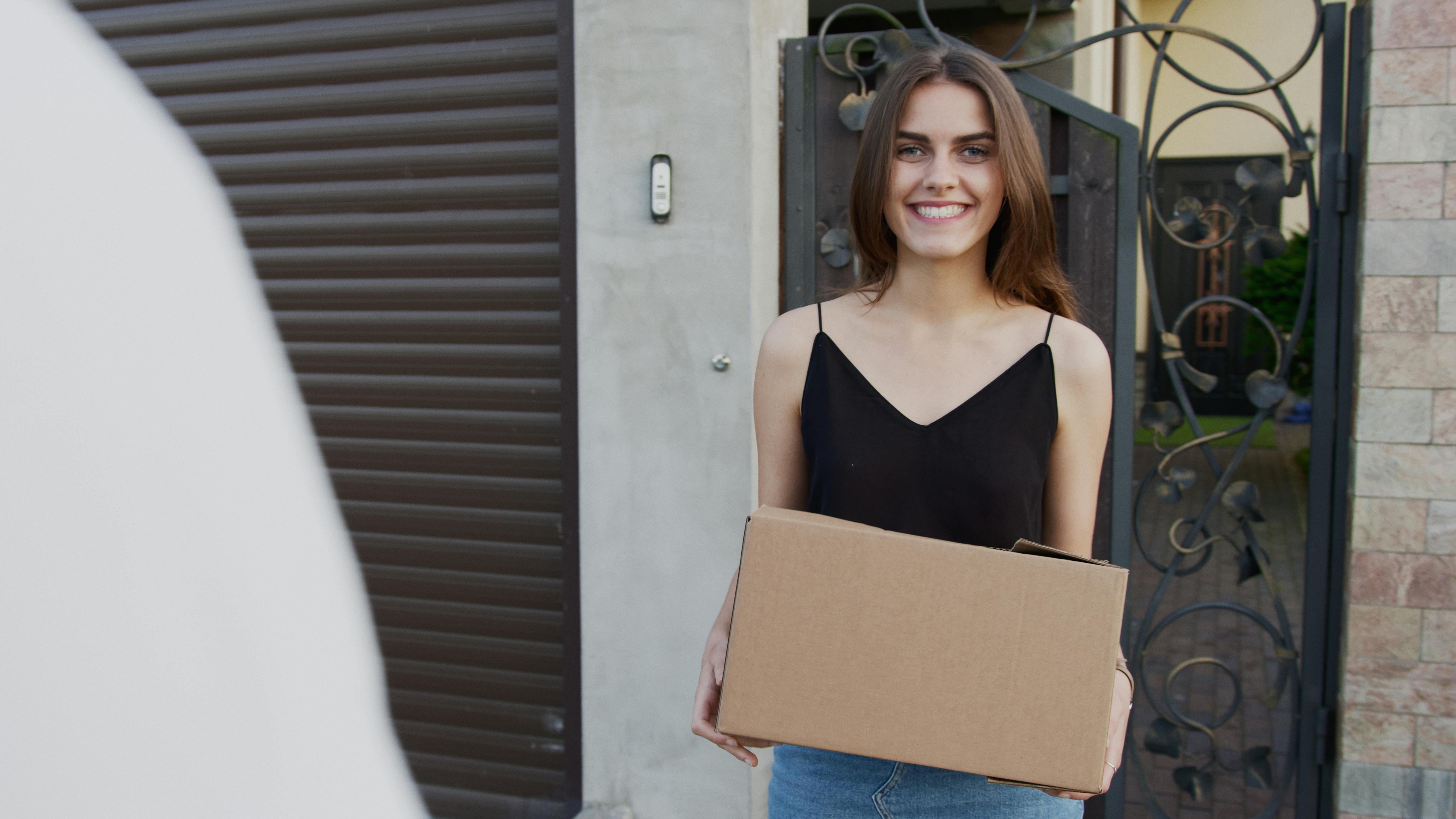 A happy woman holding a box | Source: Pexels