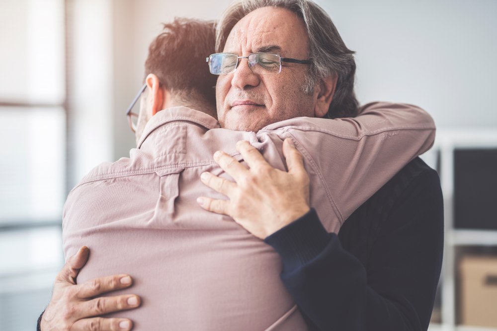 A photo of a young man hugging an older man | Photo: Shutterstock
