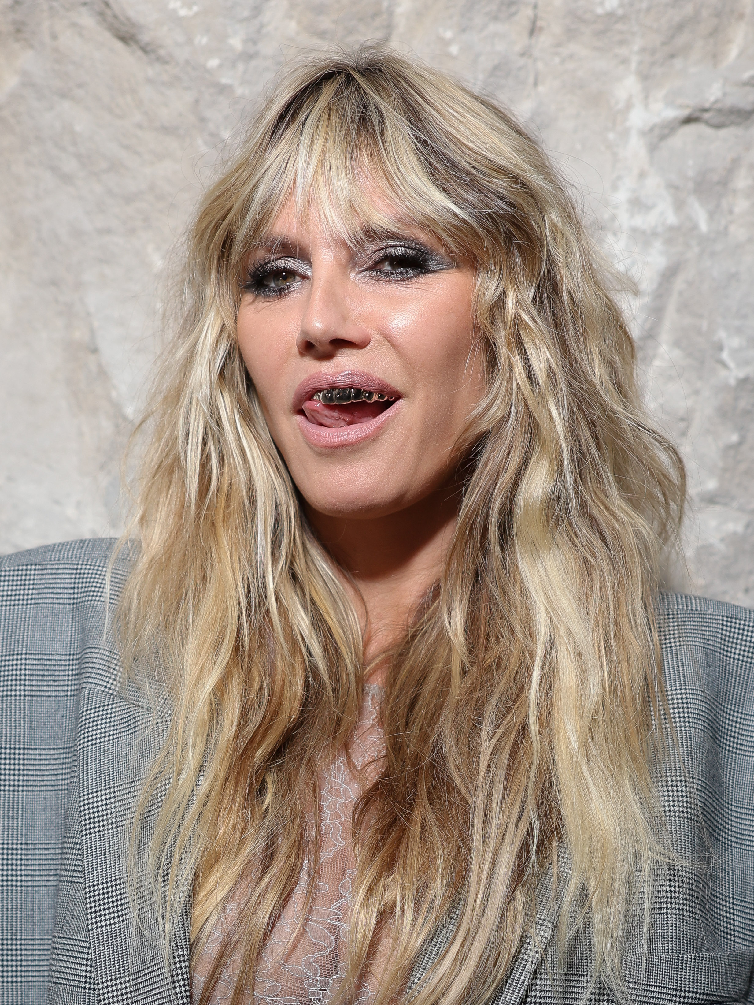 A much closer shot leaves no doubt that Heidi Klum is reveling in her gold grillz. They gleam under the lights, adding an extra edge to her daring look and revealing just how far the model is willing to go for an audacious statement.