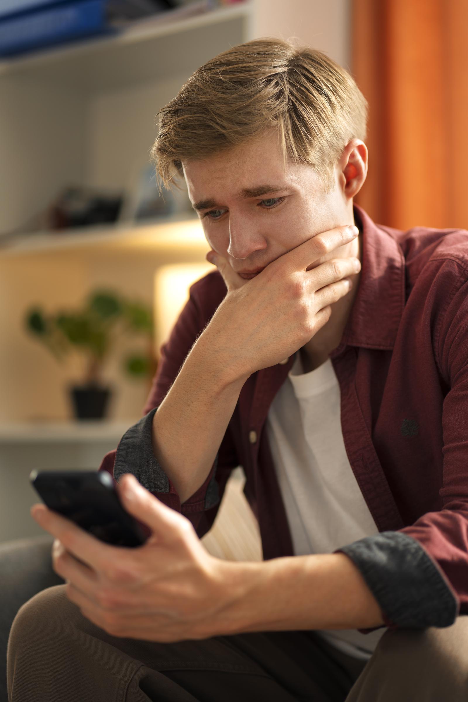 A bewildered man looking at his phone | Source: Freepik