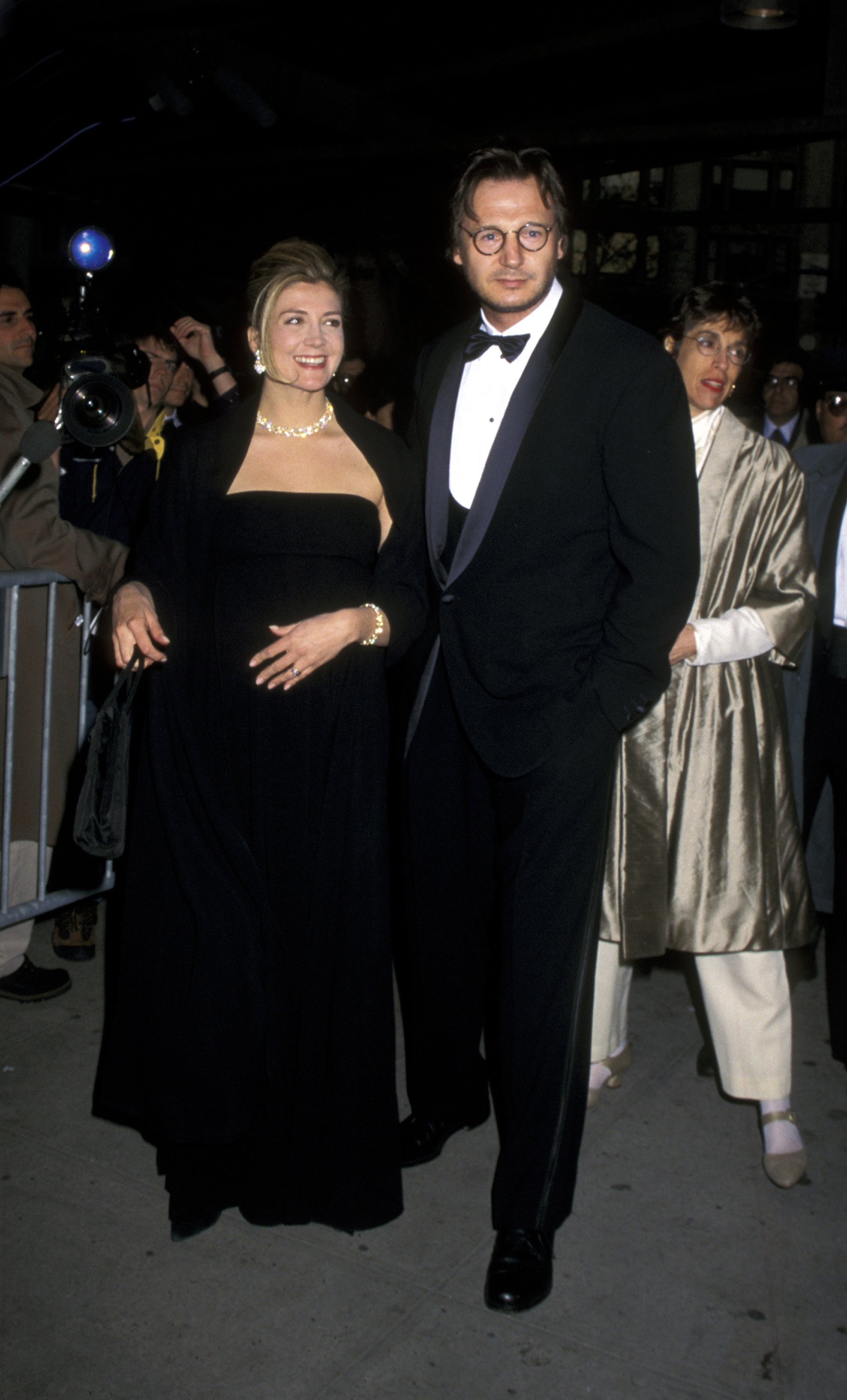 Natasha Richardson and Liam Neeson arrive at Avery Fisher Hall in New York City for the Film Society of Lincoln Center event honoring Clint Eastwood on May 6, 1996. The couple stands arm in arm on the red carpet as photographers capture their entrance.
