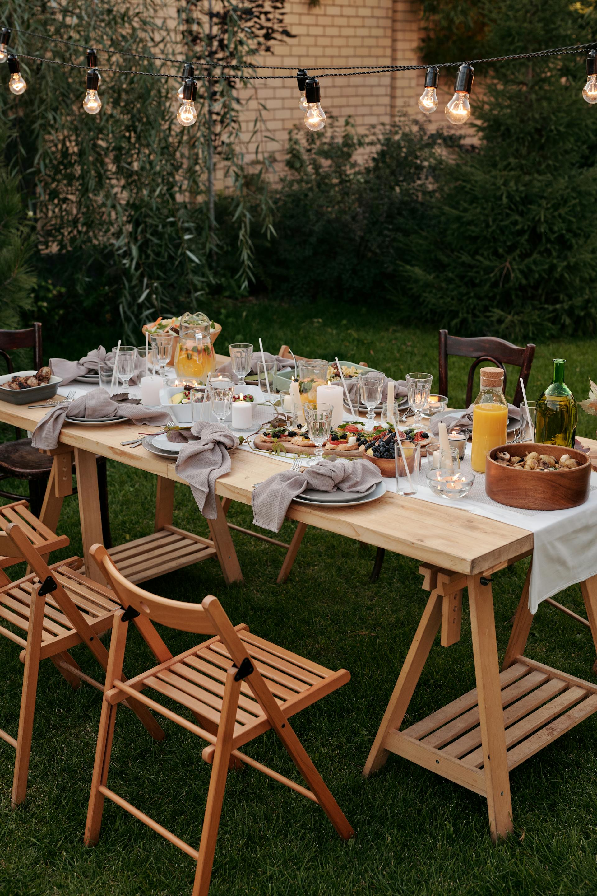 Food served on a brown wooden table with chairs and plates | Source: Pexels