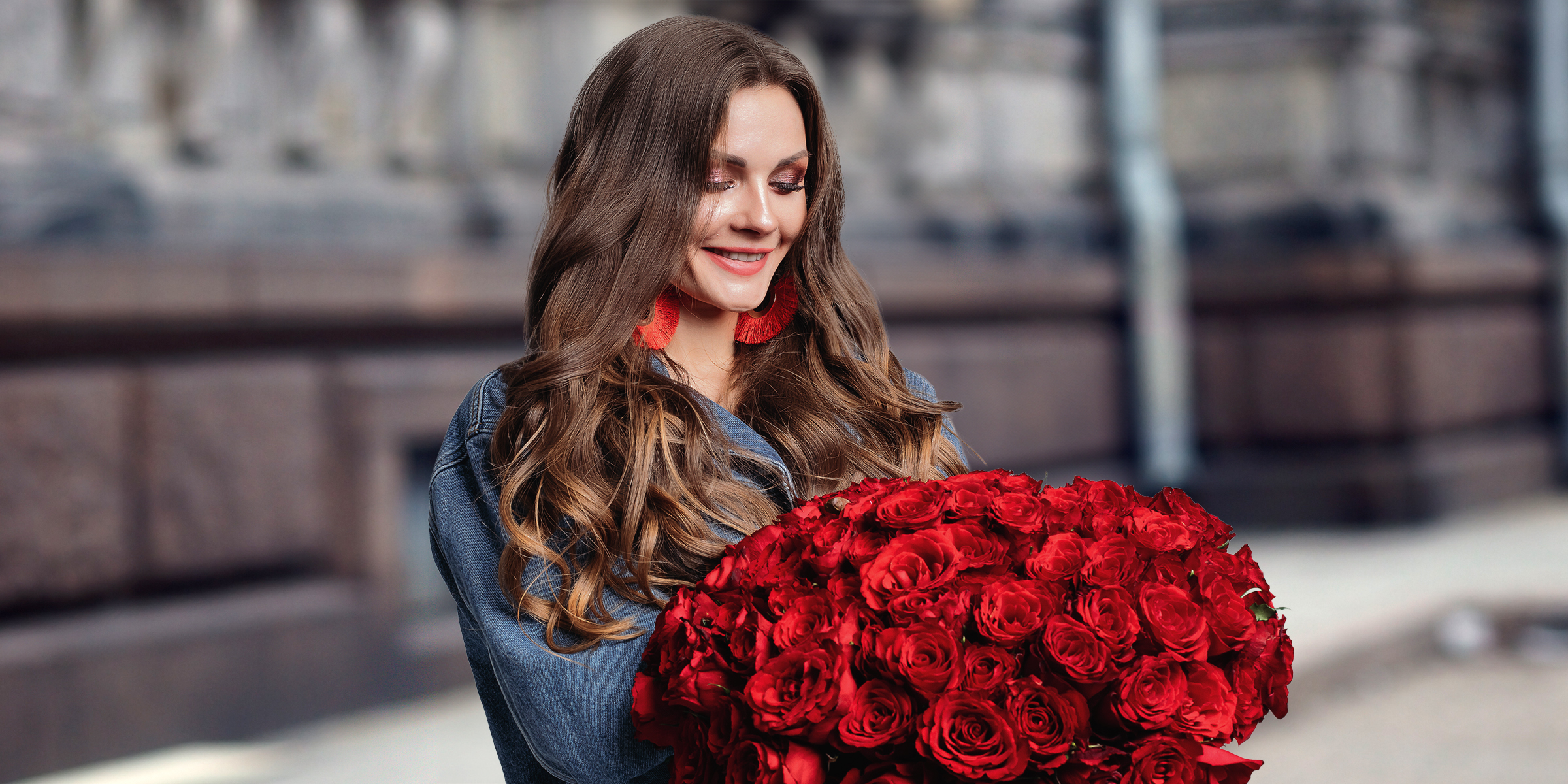 A happy woman holding a bouquet of red roses | Source: Shutterstock
