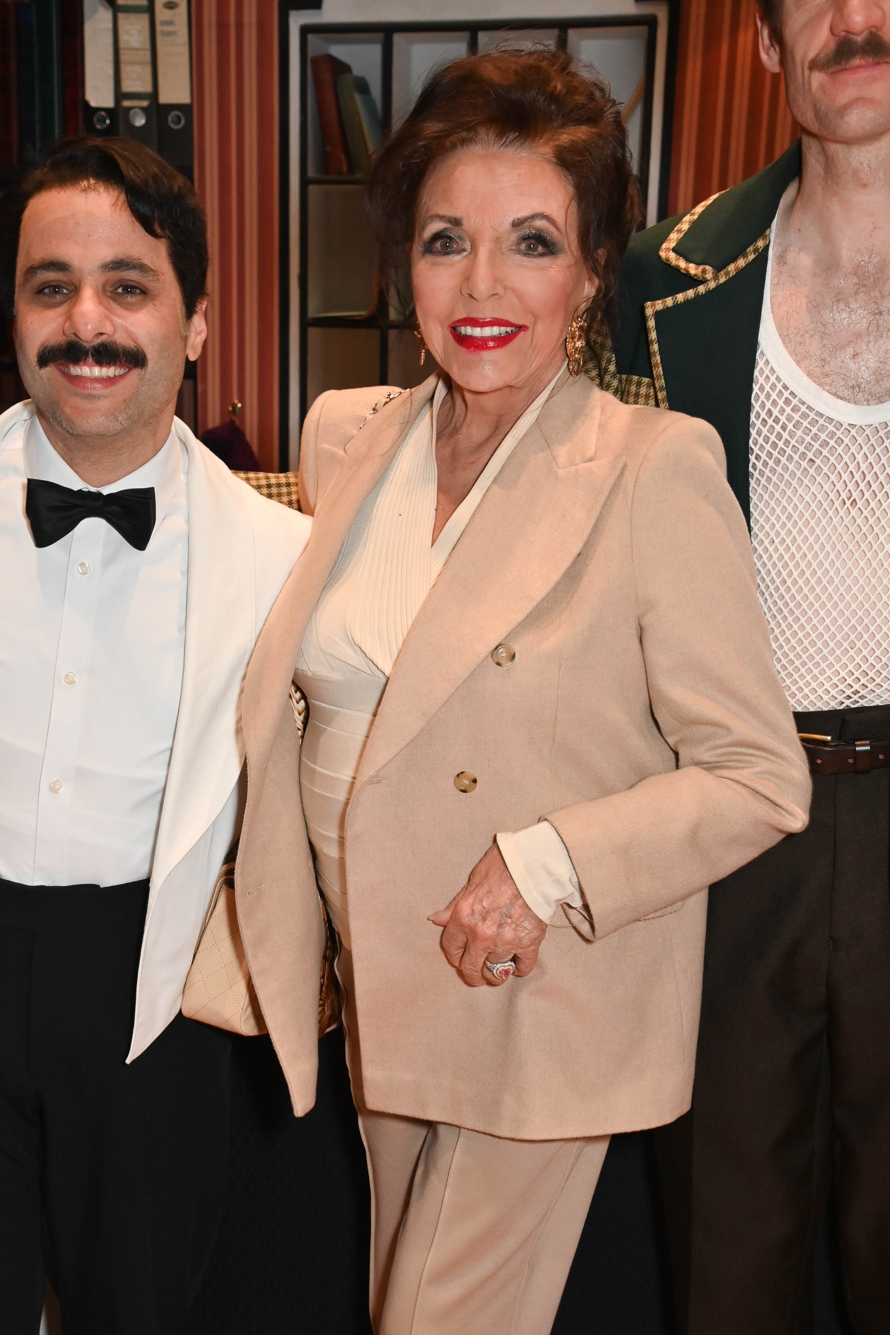 Joan Collins posing backstage with the cast of "Fawlty Towers: The Play" on May 29, 2024, in London, England. | Source: Getty Images