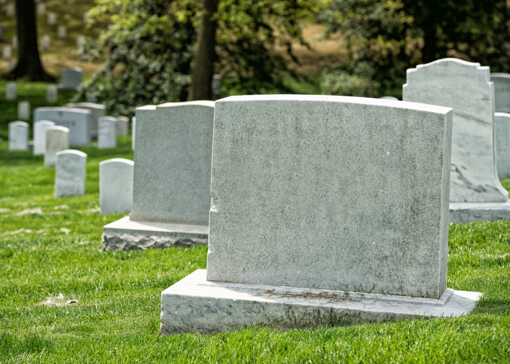 A cemetery graveyard with white tombstones. | Photo: Shutterstock