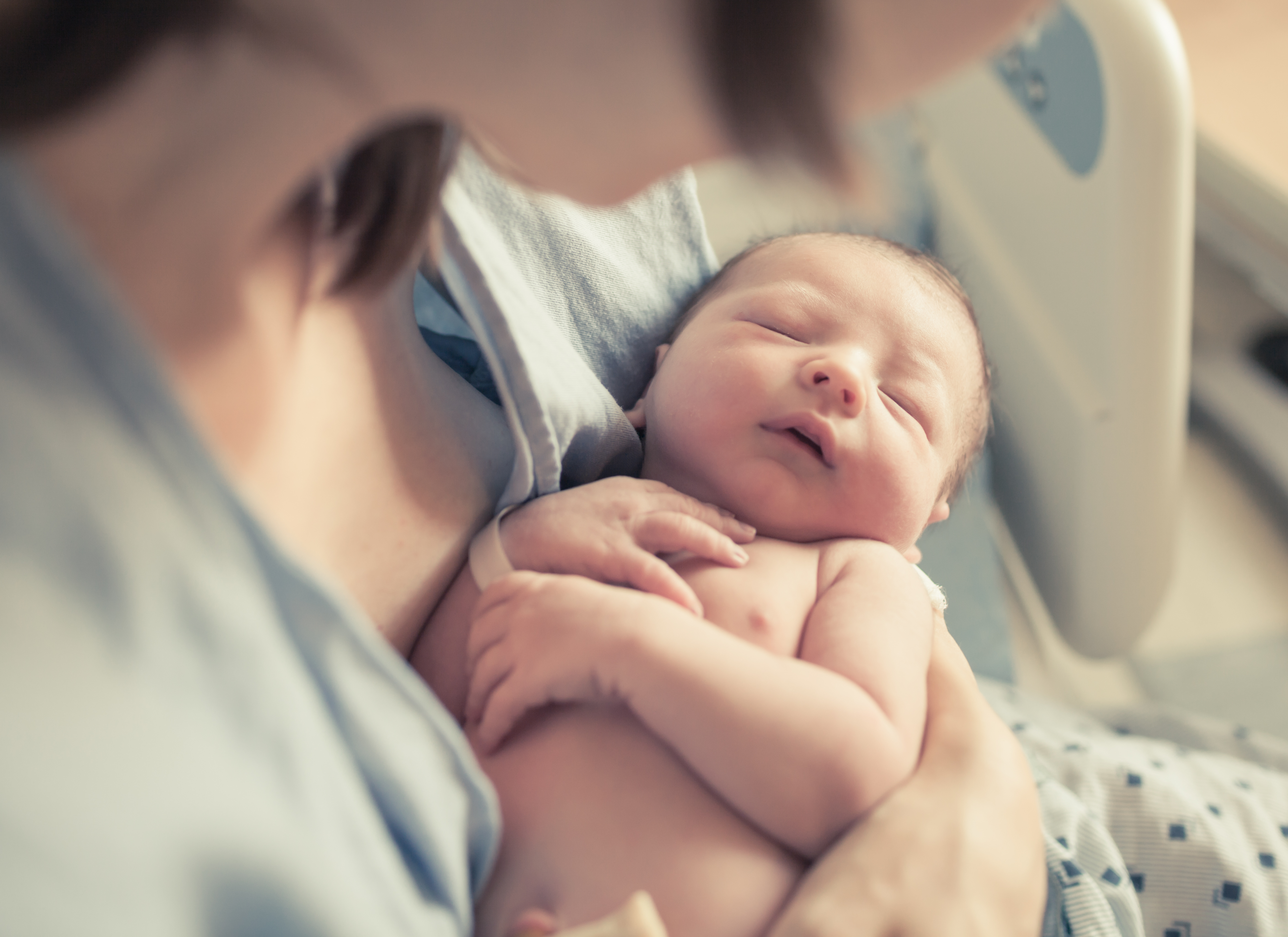 A mother cradling her newborn baby | Source: Shutterstock