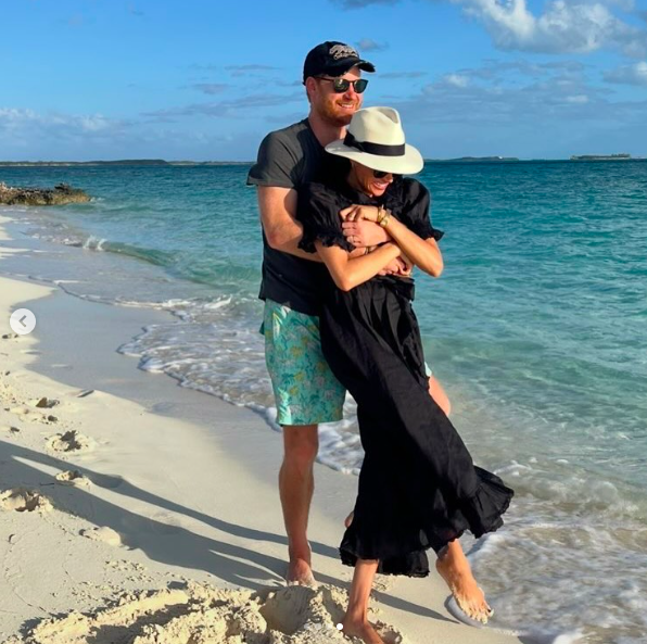 Prince Harry lovingly hugging Meghan Markle as the two smiled and posed for a photo on the beach. | Source: Instagram/meghan