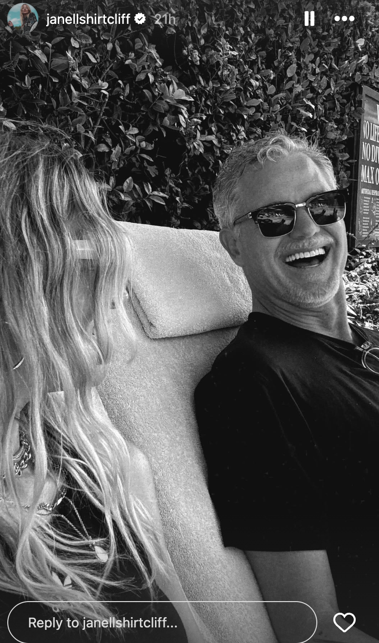 Eric Dane and Janell Shirtcliff laughing while sitting on outdoor lounge chairs, on a story posted on February 21, 2026 | Source: Instagram/janellshirtcliff