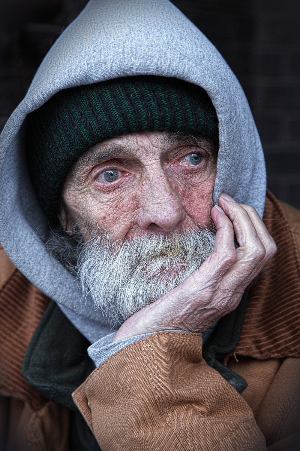 Anciano sin hogar con rostro triste apoyando su mejilla sobre su mano. | Foto: Pixabay