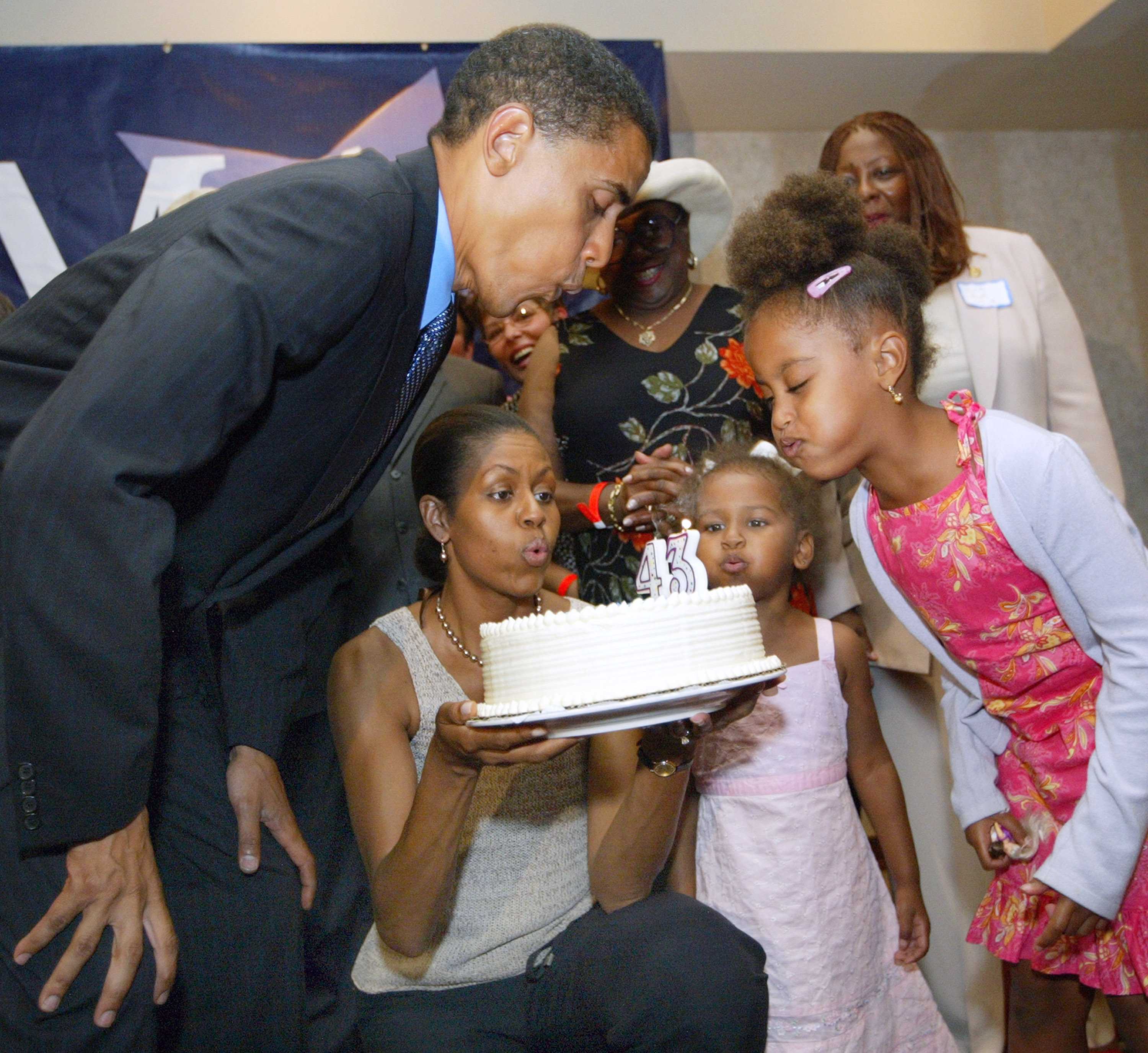 Barack Obama blowing out candles on his birthday cake at his 43rd birthday celebration with Michelle and their daughters during a fundraiser on August 4, 2004, in Matteson, Illinois. | Source: Getty Images