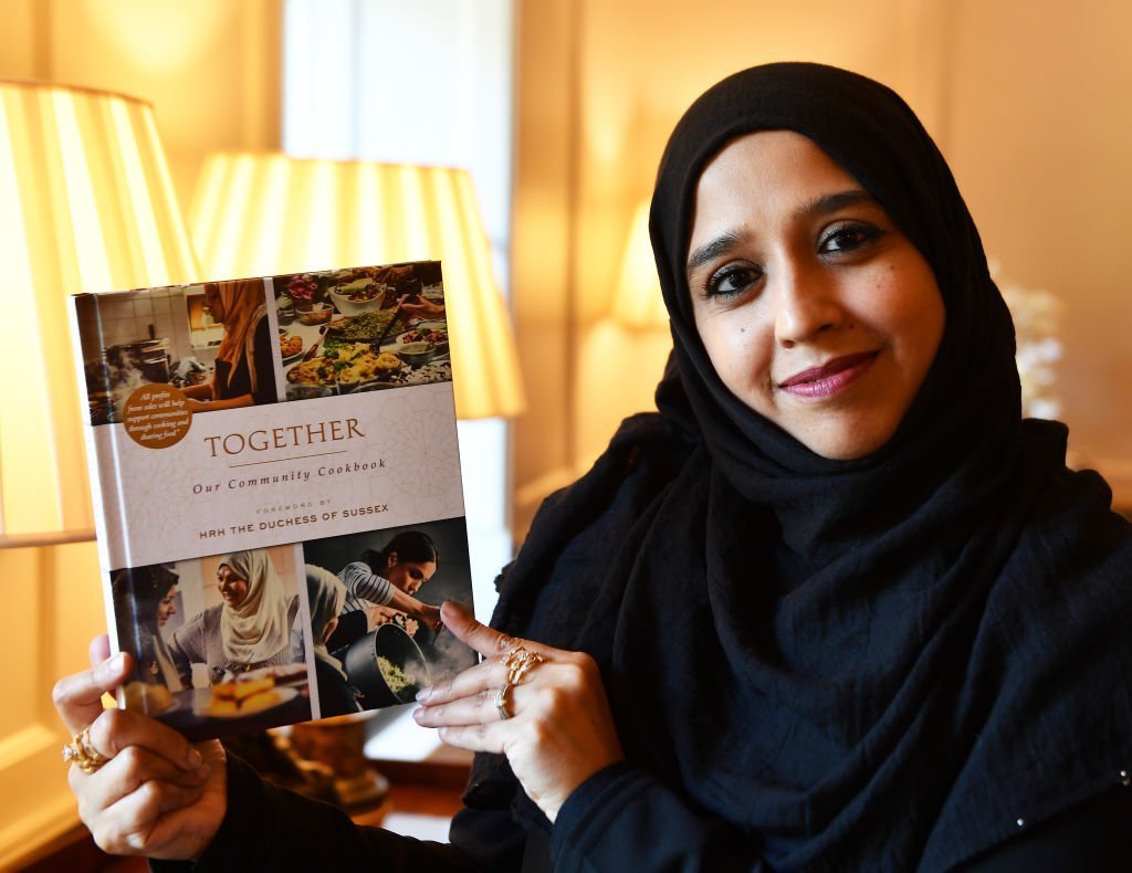Zahira Ghaswala hols a copy of 'Together' a book that tells how women came together after the Grenfell Tower tragedy to cook for the local community, which has a foreword by the Duchess of Sussex at Kensington Palace. | Photo: Getty Images