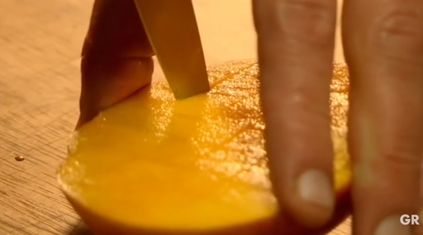 Gordon Ramsay scores the flesh of a mango into small cubes without cutting through the skin, a simple technique that makes the fruit easy to turn inside out and slice into neat, bite-sized pieces. | Source: YouTube/ Gordon Ramsay