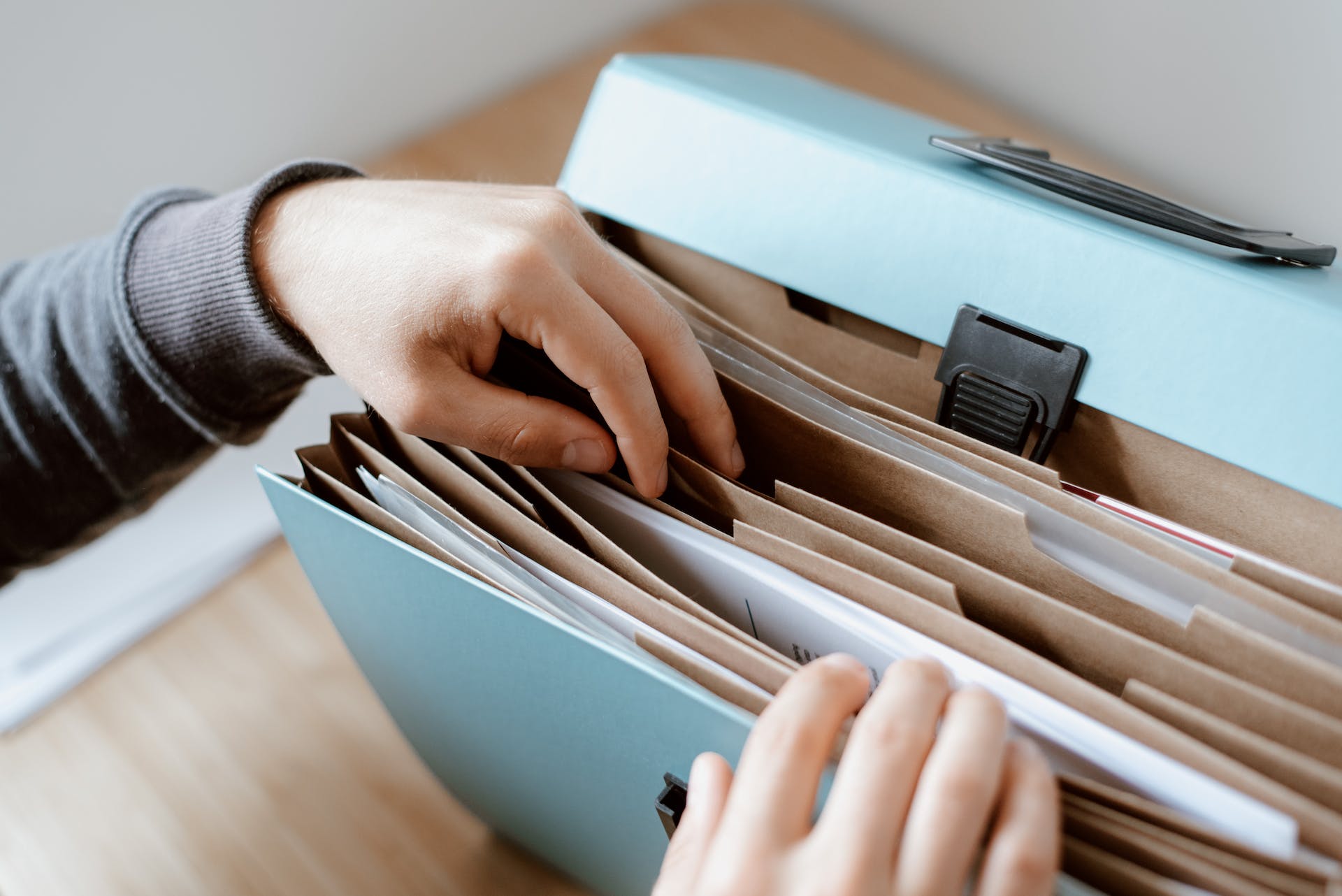 A person holding a folder of documents | Source: Pexels