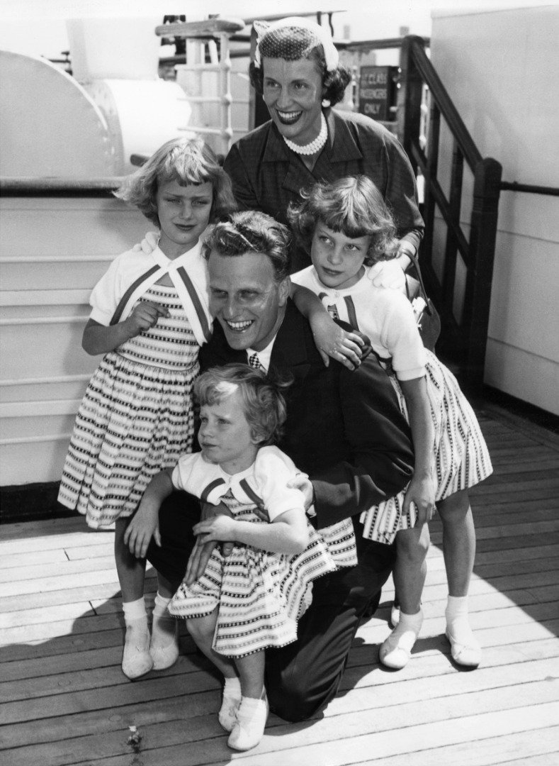 Billy Graham, the American evangelist, is greeted by his wife and children, Virginia,  Anne, and Ruth (Bunny), (foreground) aboard the liner "Queen Mary" on his return to New York 07 June 1954 from a religious tour of Europe. | Source: Getty Images