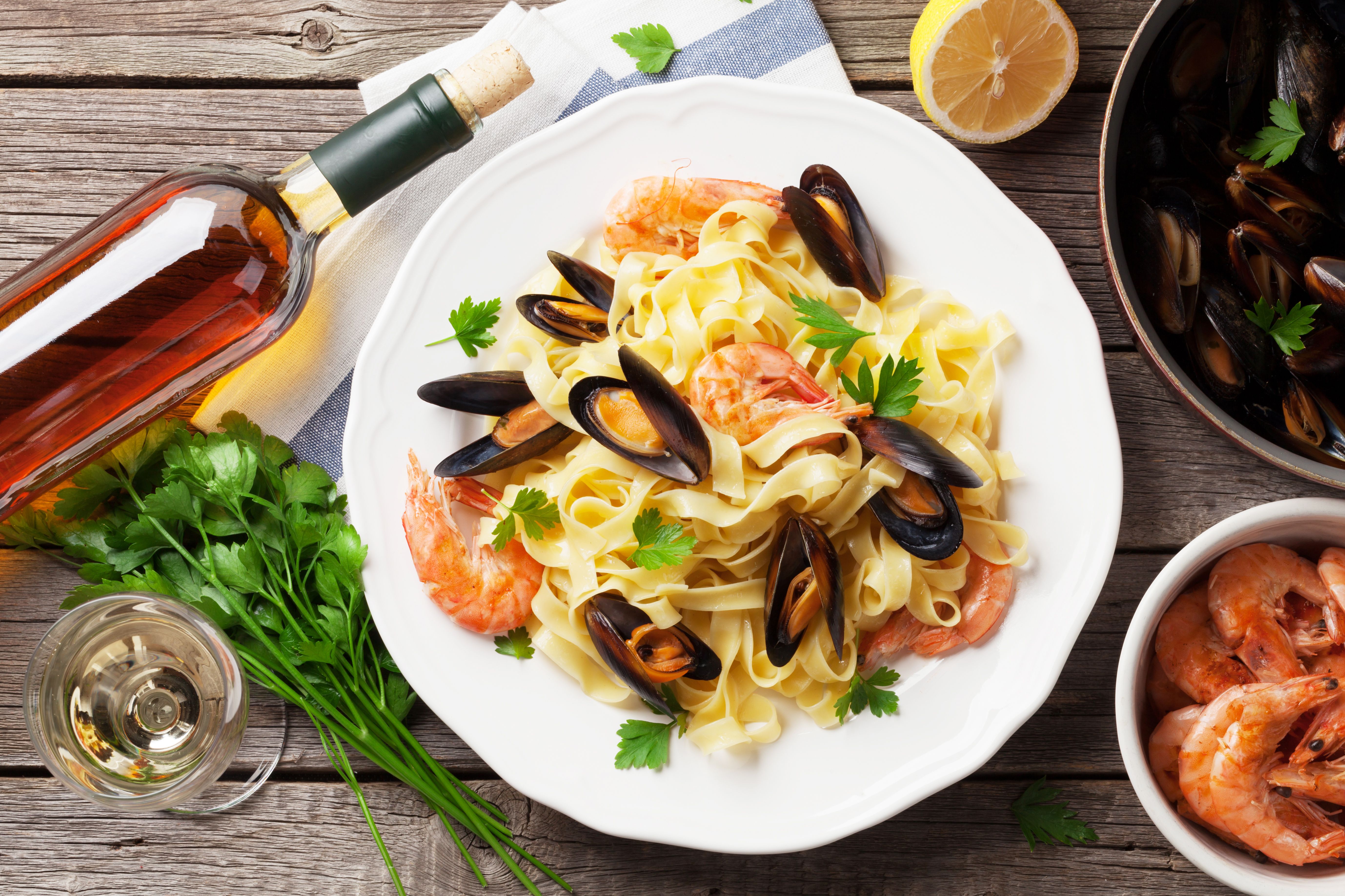 An assortment of seafood with a bottle of wine. │ Source: Shutterstock