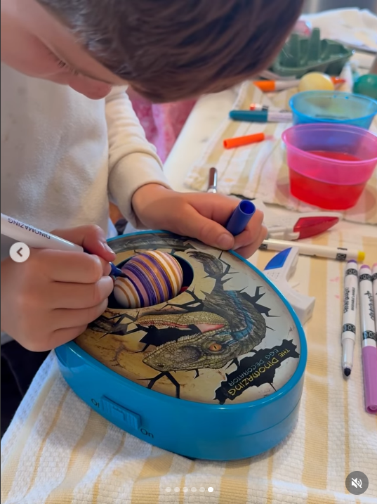 Photo of Archie decorating an egg-shaped object from a video dated April 6, 2026. | Source: Instagram/meghan