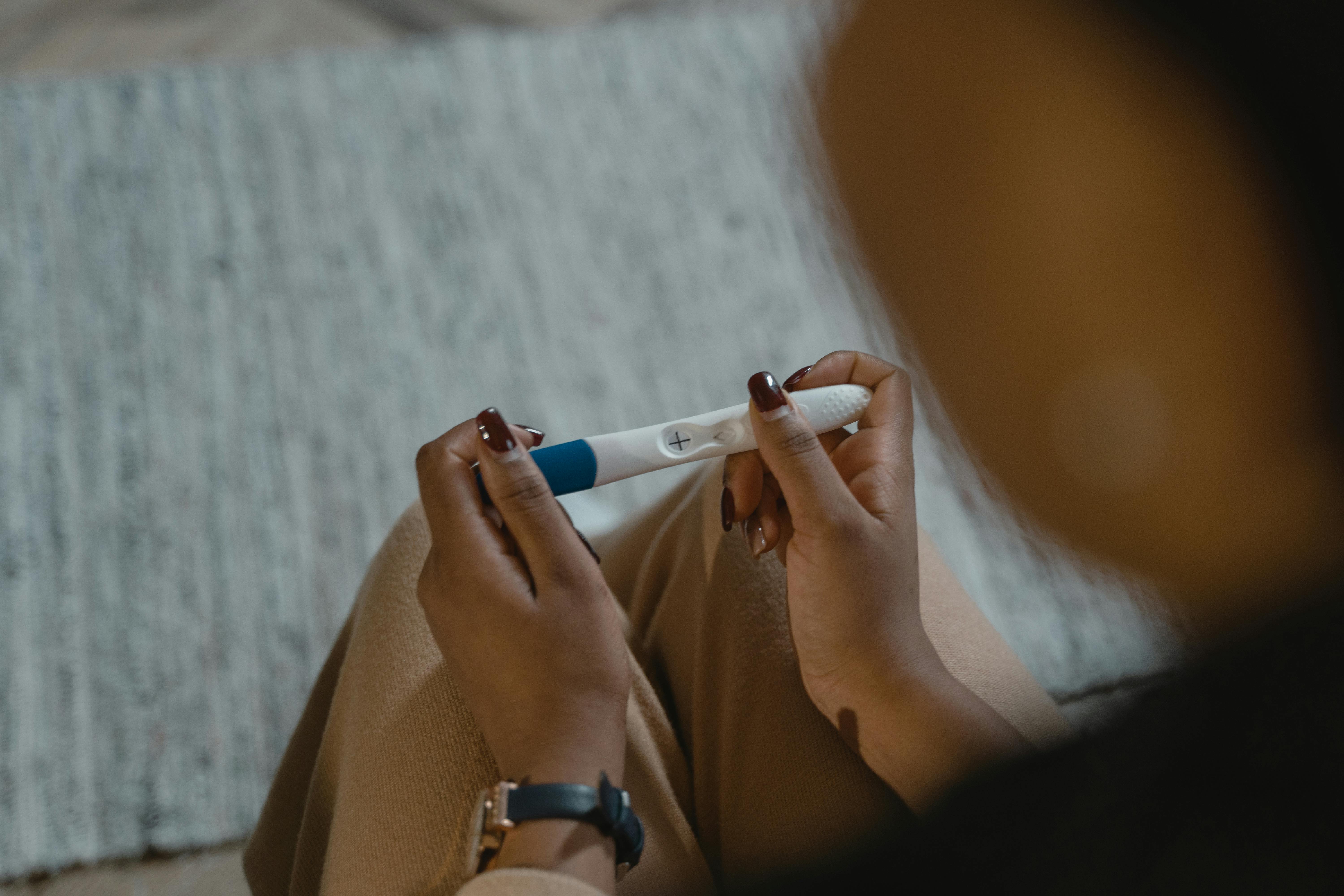 A woman holding a pregnancy test | Source: Pexels