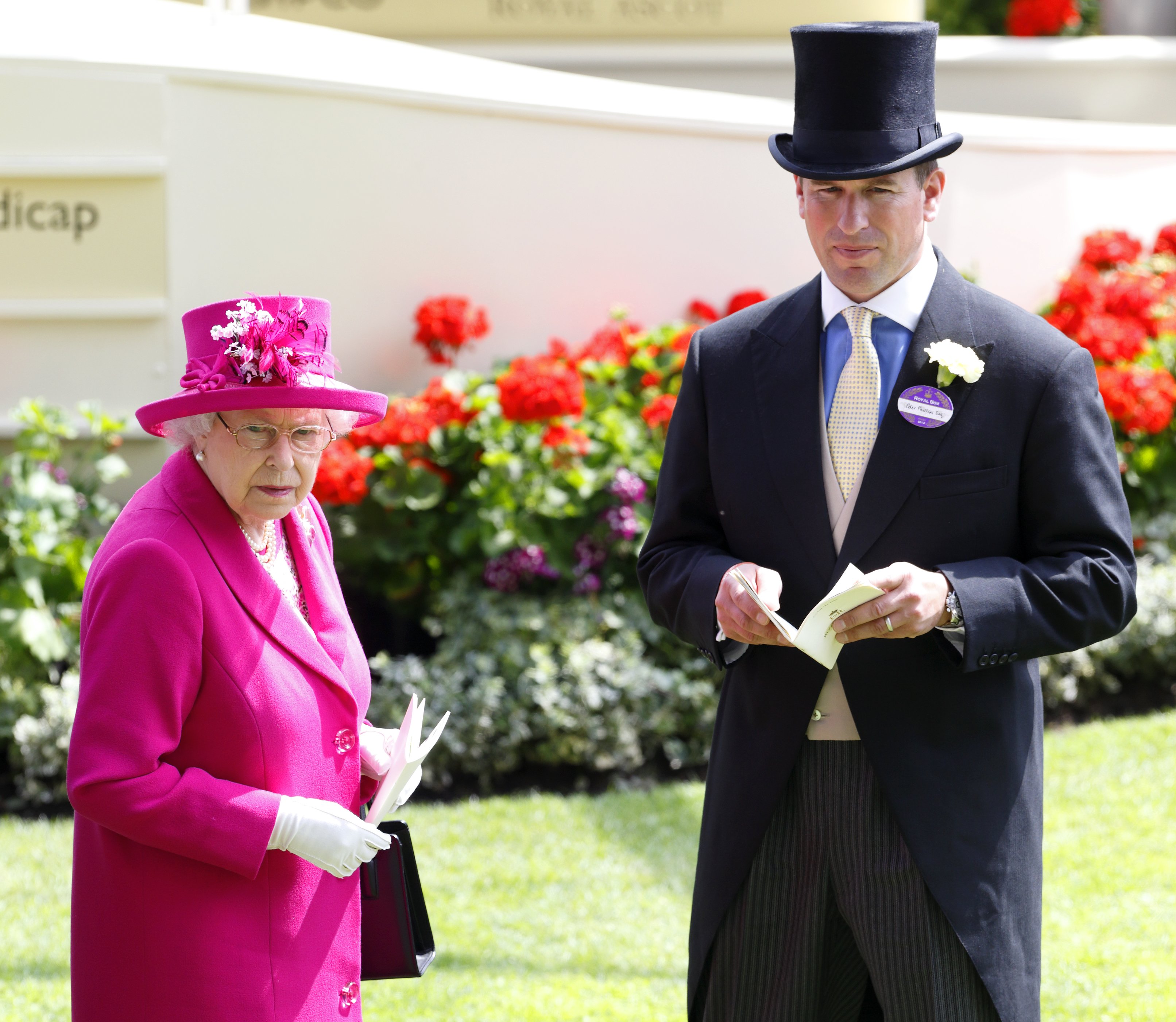 Queen Elizabeth II and her grandson Peter Phillips watch the horses in the parade ring on Day 4 of Royal Ascot at Ascot Racecourse on June 20, 2014 in Ascot, England | Source: Getty Images