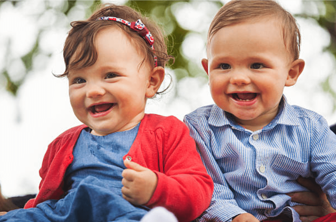 Gemelos niño y niña con una sonrisa roja para la foto | Imagen: Getty Images  