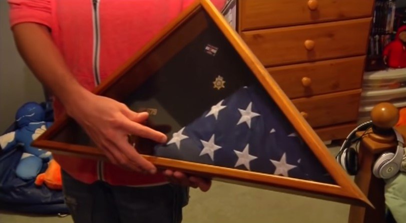 Picture of Tanner Brownlee holding a memorabilia of his late father | Source: Youtube/Denver7 – The Denver Channel