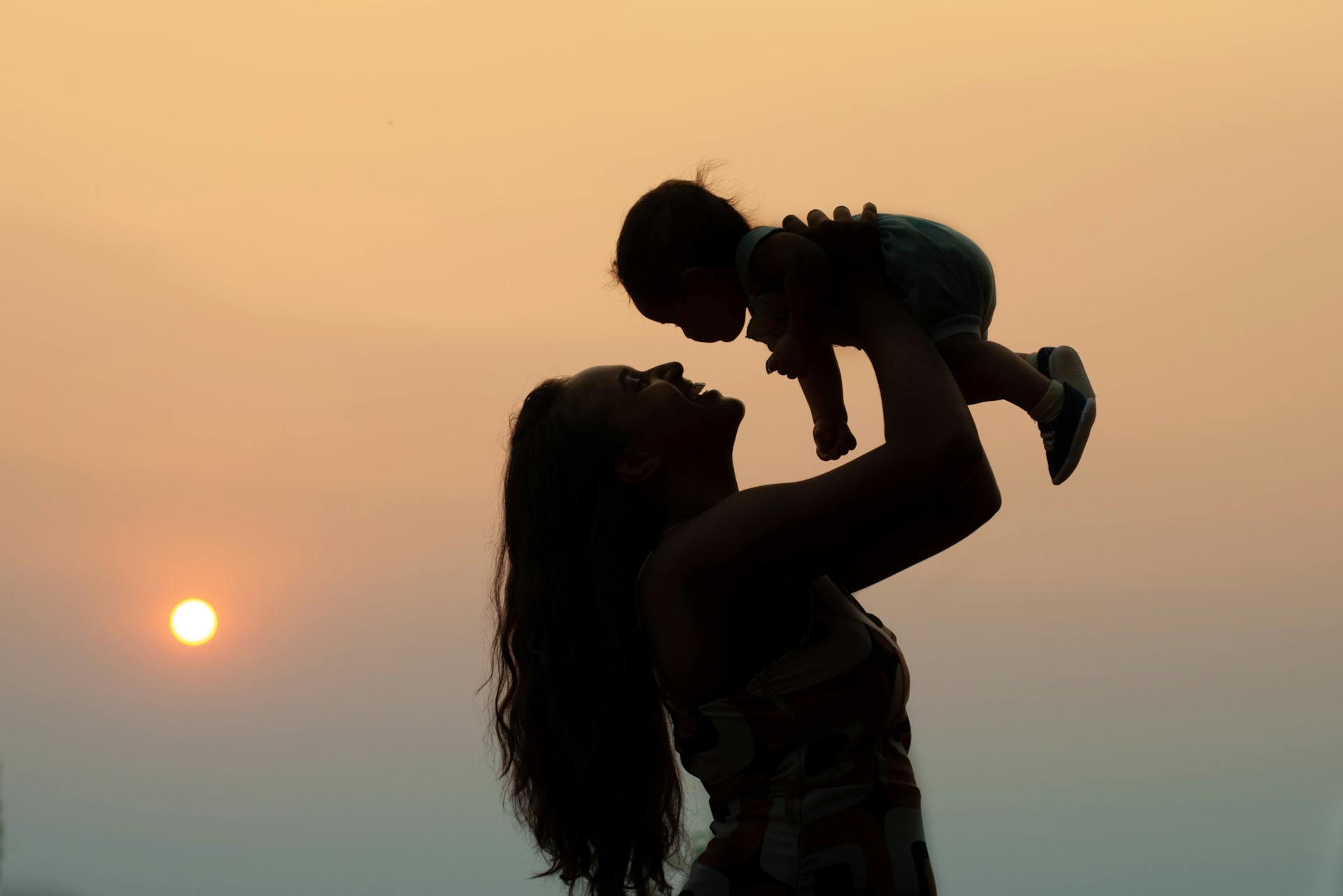 A silhouette of a woman carrying a baby | Source: Pexels