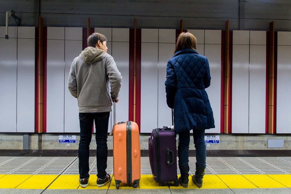 A man and a woman waiting a train subway at the train station. | Photo: Shutterstock